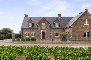 Te midden van de uitgestrekte velden, toch vlot bereikbaar dankzij de nabijheid van belangrijke invalswegen, bevindt zich deze karaktervolle villa...