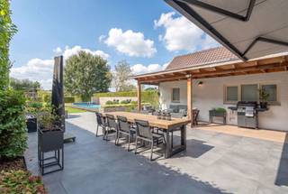 <p>Aan de Steenweg Weelde 68 in Poppel vinden we deze ruime en sfeervolle gezinswoning op een perceel van 1.717 m². De woning werd door de jaren heen goed onderhouden en op verschillende vlakken vernieuwd. Zo werden de technieken aangepakt en werd o.a. geïnvesteerd in zonnepanelen en een laadpaal.</p>
<p>Met vier slaapkamers, ruime leefruimtes, een grote zolder, inpandige garage en een prachtig aangelegde tuin met verwarmd zwembad biedt deze woning volop ruimte en comfort voor het hele gezin.</p>
<p><strong>Sfeervol wonen<br /></strong>De woonkamer straalt een warme, huiselijke sfeer uit. De parketvloer, originele deuren, sierlijsten en houtkachel zorgen voor een mooie combinatie van sfeer en authenticiteit.</p>
<p>Via de authentieke deuren bereikt u de eetkamer. Dankzij de grote schuifpui staat deze ruimte rechtstreeks in verbinding met de achtertuin. De grote raampartijen zorgen bovendien voor een aangename lichtinval.</p>
<p>Daarnaast beschikt de woning over een praktische achterinkom met een toilet en een extra berging.</p>
<p><strong>Ruime, complete keuken<br /></strong>De keuken is voorzien van alle nodige comfort, waaronder een 5-pits inductiekookplaat.</p>
<p>Vanuit de keuken heeft u toegang tot de voorraadberging en de kelder. De kelder is droog en volledig betegeld.</p>
<p>Aansluitend aan de keuken bevindt zich aan de voorzijde van de woning het bureau. Deze ruimte beschikt over openslaande deuren en ingebouwde kasten in dezelfde stijl als de keuken. Een veelzijdige ruimte die perfect kan dienen als thuiswerkplek of hobbyruimte.</p>
<p><strong>Vier slaapkamers, badkamer en wasruimte<br /></strong>Op de eerste verdieping bevinden zich vier volwaardige slaapkamers. De master bedroom beschikt over een dressing met ingebouwde kasten.</p>
<p>De badkamer is uitgerust met een inloopdouche, dubbele wastafel en ligbad. Het toilet bevindt zich afzonderlijk.</p>
<p>Ook de praktische wasruimte bevindt zich op deze verdieping en is voorzien van aansluitingen voor wasmachine en droogkast en er is een wastafel.</p>
<p><strong>Zolder met mogelijkheden<br /></strong>De zolder biedt heel wat potentieel. Afhankelijk van de wensen van de nieuwe eigenaar kan deze ruimte verder worden ingericht als extra slaapkamers met badkamer, hobbyruimte of andere multifunctionele ruimte.</p>
<p>Er is reeds een afvoer voorzien, wat mogelijkheden biedt voor een toekomstige verbouwing.</p>
<p><strong>Garage en extra bergruimte<br /></strong>De woning beschikt over een inpandige garage. Via een vlizotrap bereikt u bovendien een praktische bergzolder, ideaal voor extra opslag.</p>
<p><strong>Een tuin als verlengstuk van de woning<br /></strong>De fraai aangelegde tuin is zonder twijfel een van de grote troeven van deze woning. De groene omgeving biedt veel privacy en verschillende plekken om te ontspannen.<br /><br />De overkapping aan de woning biedt een aangename plek om beschut van de tuin te genieten.</p>
<p>Het verwarmde zwembad zorgt tijdens de warme maanden voor een heerlijk vakantiegevoel in eigen huis. Dankzij de warmtepomp kan het zwembad aangenaam worden verwarmd en met de aanwezige buitendouche is ook extra comfort voorzien.</p>
<p>De tuin beschikt daarnaast over verschillende fruitbomen en struiken, waaronder peren, appels, pruimen, noten en druiven. Voor de kinderen is er een speeltoestel en ook een kippenren maakt deel uit van het geheel.</p>
<p>Daarnaast werd in 2020 een praktisch bijgebouw geplaatst, ideaal voor het stallen van bijvoorbeeld tuinmateriaal.</p>
<p><strong>Troeven op een rij:</strong><br />- Verwarmd zwembad met warmtepomp en buitendouche<br />- Ruime, groene tuin met veel privacy<br />- Zonnepanelen en laadpaal<br />- Sfeervolle woonkamer met parketvloer, originele deuren, sierlijsten en houtkachel<br />- Zolder met uitbreidingsmogelijkheden<br />- Inpandige garage en extra bergzolder<br />- Vernieuwde technieken en diverse recente investeringen<br /><br />Vermelde oppervlakten zijn indicatief. Oppervlakte conform EPC.</p>
