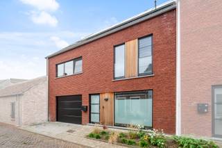 In een rustige woonomgeving nabij het centrum van Zele bevindt zich deze recente en eigentijds vormgegeven gezinswoning uit 2023. De opvallende gevelbreedte, strakke architecturale lijnen en combinatie van karaktervolle baksteen met warme houten accenten geven de woning meteen een bijzondere uitstraling. Binnen zorgen de royale proporties, grote raampartijen en open leefstructuur voor een aangenaam gevoel van ruimte, licht en gezelligheid. De stijlvolle keuken met kookeiland vormt samen met de leefruimte het warme hart van de woning en staat rechtstreeks in verbinding met de ruime, volledig omheinde tuin. Ook in de verdere afwerking zorgen natuurlijke houttinten en zachte materialen voor een warme en huiselijke sfeer. De eerste verdieping omvat drie slaapkamers, waaronder de master bedroom met aansluitende dressing, en een moderne badkamer. Op de tweede verdieping bevinden zich nog twee volwaardige slaapkamers en een technische ruimte. Met ca. 190 m² netto bewoonbare oppervlakte en 235m² bruto oppervlakte volgens het EPB-verslag, vijf slaapkamers, een inpandige garage en een uitstekend EPC van slechts 29 kWh/m² combineert deze woning ruimte en comfort met energiezuinig wonen en beperkte energiekosten. Een recente, instapklare woning met een uitgesproken architectuur, royale gevelbreedte en een verrassend warme uitstraling, waar comfort, gezelligheid en energiezuinigheid mooi samenkomen. De woning wordt aangeboden aan het verlaagde tarief van 2% registratiebelasting, mits voldaan is aan de wettelijke voorwaarden voor de aankoop van de enige eigen woning. Wees er snel bij, want woningen met deze troeven zijn schaars!