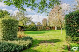 <p><span>Landelijk wonen in Kalmthout op een prachtig perceel van 2.500m² met onder meer lichtrijke leefruimte, vier slaapkamers, ingerichte keuken en inpandige garage.</span></p><p><span>0p zoek naar een ruime woning met karakter, privacy en volop mogelijkheden? Deze landelijke woning in Kalmthout is gelegen op een uitzonderlijk ruim en groen perceel en vormt een ideale basis voor wie rustig wil wonen en tegelijk zijn eigen woonideeën wil realiseren. </span></p><p><span>INDELING</span></p><p><span> </span></p><p><span>Gelijkvloers</span></p><p><span> </span></p><p><span>Bij het binnenkomen betreedt u de hal op tegelvloer. Naastgelegen bevindt zich de lichtrijke leefruimte onderverdeeld in twee zithoeken en een eetgedeelte. De ruime praktische leefkeuken kijkt uit over tuin. Verder beschikt men over een bijkeuken met voorzieningen voor wasmachine en droogkast. Vanuit hier bereikt men de inpandige garage met automatische toegangspoort. </span></p><p><span> </span></p><p><span>Op het gelijkvloers bevindt zich een apart toilet.</span></p><p><span> </span></p><p><span>Eerste verdieping</span></p><p><span> </span></p><p><span>De eerste beschikt over een ruime overloop, vier volwaardige slaapkamers en een ingerichte badkamer met ligbad, toilet en lavabo. </span></p><p><span> </span></p><p><span>Verder bereikt men door middel van een vlizotrap de ruime zolder welke eveneens geschikt is voor eventuele uitbreiding. </span></p><p><span>De woning is grotendeels onderkelderd met een kruipkelder, die onder meer interessant is voor het plaatsen van bijkomende isolatie.</span></p><p><span>Tuin</span></p><p><span>De privatieve tuin is een absolute troef. Dankzij de parkachtige uitstraling, de volwassen groene omgeving en de royale oppervlakte geniet u hier van ruimte en volledige privacy. Achteraan het perceel bevindt zich een grote moestuin, volwassen fruitbomen waaronder druivelaars en vijgenbomen, een grote serre en een ruim kippenren. De tuin beschikt bovendien over een garagebox en tuinhuis, ideaal voor opslag. </span></p><p><span>Vooraan de woning is er voldoende parkeergelegenheid.</span></p><p><span>Een woning met mogelijkheden. </span></p><p><span>Deze eigendom combineert een landelijke ligging met een uitzonderlijk ruim perceel en een goede bestaande structuur. De woning is instapklaar wat betreft onderhoud, maar biedt tegelijk de vrijheid om de afwerking en inrichting volledig aan uw eigen smaak en woonwensen aan te passen.</span></p><p><span>Het dak is geschikt voor zonnepanelen, die vanaf het middaguur de rest van de dag in vol zonlicht staan.</span></p><p><span>Een interessante opportuniteit voor wie op zoek is naar ruimte, privacy en een groene woonomgeving in Kalmthout.</span></p><p><span>03 666 30 66 | <span>info@allure-re.com</span></span><span> | <span>www.allure-re.com</span></span><span> </span></p>