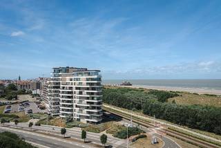 Ontdek dit exclusieve appartement in de residentie The One in Blankenberge, een architecturale parel ontworpen door A1AR architecten en gerealiseerd door projectontwikkelaar Volus. 

De lichtrijke leefruimte vormt het hart van het appartement en sluit naadloos aan op het uitzonderlijk ruime zonneterras. De 115 m² woonoppervlakte, de doordachte indeling en de verfijnde afwerking zorgen voor een tijdloze woonkwaliteit waarin comfort vanzelfsprekend aanvoelt. Dankzij de gunstige oriëntatie geniet je de hele dag van de zon, terwijl het panoramische uitzicht elke dag opnieuw een ander decor vormt. Grote raampartijen halen het buitengevoel naar binnen en creëren een aangename verbinding tussen het interieur en de omgeving. Met twee volwaardige slaapkamers en een stijlvolle badkamer biedt dit appartement alles voor wie op zoek is naar een kwalitatieve woonst aan de Belgische kust, zowel voor permanente bewoning als als tweede verblijf.

Als resident van The One geniet je bovendien van een exclusieve gemeenschappelijke lounge met panoramisch zeezicht. Deze stijlvolle ruimte kan je reserveren om samen met familie of vrienden te genieten in een uitzonderlijk kader, een unieke troef die het luxueuze karakter van het gebouw extra onderstreept.

Meerdere ruime garageboxen kunnen optioneel worden aangekocht aan €105.000 per box, een absolute meerwaarde op deze gegeerde locatie.

Ben je op zoek naar een exclusief appartement waar architectuur, ruimte, licht en uitzicht perfect samenkomen? Contacteer Dries voor een persoonlijke rondleiding of meer informatie via 0475 57 40 19 of dries@keyimmo.be.