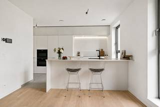 Deze woning komt in aanmerking voor <strong>het verlaagde btw-tarief van 6% voor sloop en heropbouw</strong> (onder voorwaarden), zowel voor eigen bewoning als voor investeerders.<br /><br />Ontdek deze prachtige nieuwbouwwoning in het rustige en groene <strong>Handbogenhof</strong> te <strong>Lier</strong>. Deze moderne en energiezuinige woning combineert een hoogwaardige afwerking met een doordachte indeling over drie niveaus en biedt bovendien een unieke mogelijkheid tot <strong>praktijkwoning</strong> dankzij de aparte inkom en multifunctionele ruimtes op het gelijkvloers.<br /><br />Bij het betreden van de woning komt u op het gelijkvloers in een ruime inkomhal die toegang geeft tot twee polyvalente ruimtes, ideaal als praktijk, bureau of extra slaapkamers. Verder vindt u hier een eerste badkamer, een aparte toiletruimte, een technische berging en extra opbergruimte. Dankzij deze indeling is het perfect mogelijk om wonen en werken te combineren met behoud van privacy.<br /><br />Op de eerste verdieping bevindt zich de lichtrijke leefruimte met open zicht en een aangename doorzonbeleving. De volledig uitgeruste keuken met kookeiland sluit naadloos aan op de eetruimte en zithoek en is voorzien van alle comfort, waaronder inductiekookplaat, combi-ovens, koelkast met diepvries, vaatwasser en dubbele spoelbak. Aansluitend is er een praktische berging. Vanuit de leefruimte heeft u toegang tot het ruime terras, ideaal om te ontspannen.<br /><br />De tweede verdieping omvat het nachtgedeelte met drie slaapkamers, waaronder een ruime master bedroom met aansluitende dressing. Daarnaast beschikt deze verdieping over een tweede badkamer met ligbad en dubbele lavabo, een apart toilet en een extra dressing of bergruimte in de nachthal.<br /><br />Verder beschikt de woning over twee terrassen, wat zorgt voor extra buitenruimte en wooncomfort.<br /><br />Een autostaanplaats kan mee aangekocht worden voor €35.000.<br /><br />Troeven:<br />+ Mogelijkheid tot praktijkwoning (aparte inkom + 2 praktijkruimtes)<br />+ Twee terrassen<br />+ Energiezuinig <br />+ Volledig uitgeruste keuken met kookeiland<br />+ Rustige ligging in Handbogenhof te Lier<br /><br />Interesse in deze woning? Contacteer ons via 03 337 50 70 of info@vbvastgoed.be voor een afspraak ter plaatse of meer info.