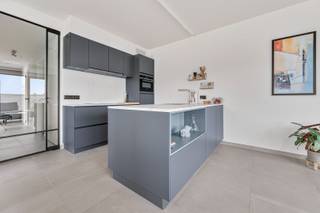 Dit kwalitatief appartement (met lift) werd opgetrokken in 2022 met veel aandacht voor energie, licht, ruimtegevoel en gebruik van hoogwaardige materialen. De indeling is als volgt: inkomhal, gastentoilet, aangename leefruimte waar de grote raampartijen een enorm wow gevoel geven, aangenaam zonneterras van ca 9m2 waar het heerlijk vertroeven is, open keuken voorzien van alle toestellen en voldoende opbergkasten. De nachthal geeft toegang tot de twee ruime slaapkamers, volledig betegelde badkamer met inloopdouche, dubbele lavabo+meubel. Het appartement beschikt eveneens over een handige berging/wasplaats. extra's: zonnescreens aanwezig, overal vloerverwarming met warmtepomp, verluchtingssysteem D, privatieve zonnepanelen, nog vrijstelling op kadastraal inkomen. Inclusief kelderberging. Aankoop van een ondergrondse autostaanplaats (25 000 euro). IDEAAL VOOR WIE RUSTIG WIL WONEN MAAR TOCH DIRECT IN EN UIT HET CENTRUM EN IN DE NABIJHEID VAN ALLE INVALSWEGEN!