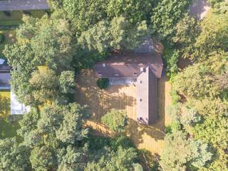 Op een prachtig, bosrijk perceel nabij het centrum van Kapellen bevindt zich deze bijzonder ruime villa uit de jaren '70. Dankzij haar royale volumes, doordachte indeling en unieke ligging vormt deze eigendom de ideale basis voor wie op zoek is naar een renovatieproject met enorm potentieel.<br /><br />Via de ruime inkomhal met gastentoilet en vestiairekasten betreedt u de lichtrijke leefruimte, bestaande uit een gezellige zithoek, een sfeervolle lager gelegen zitput met open haard en een open eetkamer. Grote raampartijen zorgen voor een mooie verbinding met de tuin en alle leefruimtes kunnen afzonderlijk worden afgesloten met een schuifwand. Aansluitend bevindt zich een praktisch kantoor met ingemaakte kasten.<br /><br />De ingerichte leefkeuken werd reeds vernieuwd en is voorzien van de nodige toestellen. Verder beschikt de woning over een dubbele inpandige garage met aansluitingen voor wasmachine en droogkast en een extra bergruimte.<br /><br />Op het gelijkvloers bevinden zich maar liefst vier slaapkamers en vier badkamers, wat tal van mogelijkheden biedt voor grote gezinnen, een kangoeroewoning of een combinatie van wonen en werken.<br /><br />De later toegevoegde verdieping, bereikbaar via een vaste trap, is nog volledig naar eigen smaak af te werken en biedt extra uitbreidingsmogelijkheden.<br /><br />Hoewel de woning een grondige renovatie vereist, biedt ze dankzij haar uitstekende locatie, ruime bewoonbare oppervlakte en uitzonderlijke indeling een unieke kans om een exclusieve droomwoning te creëren.<br /><br />De woning is rustig gelegen in een groene, residentiële omgeving, op korte afstand van het centrum van Kapellen. Winkels, scholen, openbaar vervoer en sportfaciliteiten bevinden zich in de nabije omgeving. Dankzij de vlotte verbinding naar Antwerpen en Nederland geniet u hier van een ideale combinatie van rustig wonen en een uitstekende bereikbaarheid.