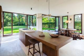 In een rustige, doodlopende straat in Schilde bevindt zich House Sylvan, een uitzonderlijke hedendaagse woning ontworpen door Maison Osaïn. De architectuur werd volledig afgestemd op haar groene omgeving, met grote raampartijen die het omliggende landschap als het ware naar binnen brengen. Het resultaat is een bijzonder lichtrijke woning waarin architectuur, interieur en natuur op een vanzelfsprekende manier samenkomen.<br /><br />Het hart van de woning wordt gevormd door de open leefruimte met keuken, eetplaats en zithoek, waarbij verschillende niveaus en een indrukwekkende dubbele hoogte zorgen voor een aangenaam gevoel van ruimte en volume. De grote glaspartijen bieden vanuit de leefruimtes een prachtig, vrij uitzicht over de omliggende weilanden en zorgen voor een sterke verbinding met de tuin.<br /><br />Ook het interieur werd door Maison Osaïn ontworpen als één harmonieus geheel. Natuurlijke materialen, hout, natuursteen en zachte aardetinten creëren een warme en tijdloze sfeer, waarbij het licht en het veranderende landschap een belangrijke rol spelen.<br /><br />De woning beschikt over ca. 270 m² woonoppervlakte op een perceel van 987 m² en omvat momenteel drie slaapkamers, met de mogelijkheid om een vierde slaapkamer te creëren, en twee badkamers. Dankzij de combinatie van een doordacht ontwerp en hedendaagse technieken geniet u hier van een hoog wooncomfort. Zo is de woning uitgerust met een warmtepomp, vloerverwarming en -koeling, zonnepanelen, ventilatiesysteem en een laadpaal voor elektrisch rijden. <br /><br />House Sylvan is een unieke combinatie van hedendaagse architectuur, hoogwaardige afwerking en rust, met het groene landschap als dagelijks decor.<br /><br />*Verkoop onder 6% btw (onder voorwaarden).<br /><br />Interesse?<br />Contacteer LISTED voor een bezoek: +32 3 283 51 51.