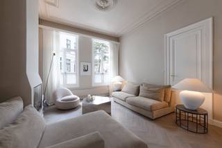 <p>On Van Noortstraat, a charming 19th-century street near the City Park, stands this townhouse, fully renovated in 2025. Laid out in 1870, the street is renowned for its beautifully preserved neoclassical townhouses. This property, with its stately white-rendered façade and tall windows, is a fine example. Behind its historic frontage lies a home that has been meticulously renovated, seamlessly combining authentic character with contemporary comfort.</p>
<p>The house unfolds around a light-filled living space extending throughout the ground floor. During the renovation, the original ornamental ceilings were carefully preserved. The herringbone parquet flooring, which runs throughout the entire house, lends every room a timeless elegance.</p>
<p>The sitting room, featuring a cosy gas fireplace, flows effortlessly into the dining area beneath a glass skylight. The adjoining SIEMATIC kitchen combines sleek contemporary design with warm, natural materials. Marble worktops and splashbacks, integrated Miele appliances, a PITTCOOKING gas hob and a Quooker tap on the central island create a refined space for cooking and gathering — the true heart of the home.</p>
<p>Large French doors open onto a charming city garden, offering a private outdoor retreat to enjoy long summer evenings.</p>
<p>An authentic staircase leads to the upper floors. The mezzanine level has been arranged as a comfortable bathroom with a double washbasin, shower and toilet.</p>
<p>The entire first floor is dedicated to a spacious master suite. Finished in the same marble as the kitchen, including matching skirting boards, and complemented by a separate guest toilet, this floor exudes understated luxury. The bedroom impresses with its high ceilings, original decorative plasterwork and elegant fireplace. An adjoining dressing room, finished in marble and fitted with bespoke storage, completes this refined private retreat.</p>
<p>The second floor features a generous second bedroom with its own en-suite bathroom, again finished with marble and herringbone flooring, ensuring a harmonious and sophisticated aesthetic throughout.</p>
<p>The third floor offers two additional bedrooms. Original exposed wooden beams highlight the home's authentic character. One of the bedrooms also features a charming mezzanine level, accessible via its own staircase, creating a unique sense of space and character.</p>
<p>The exceptional quality of the finishes is evident throughout the entire property. Air conditioning in every bedroom ensures optimal comfort during the warmer months. The house also benefits from a full basement, providing ample storage space, as well as housing the technical installations and water pressure pump. Additional features include a camera security system and a digital video intercom.</p>
<p>A parking space in a nearby car park is available for purchase at an additional price of <strong>EUR 35,000</strong>.</p>