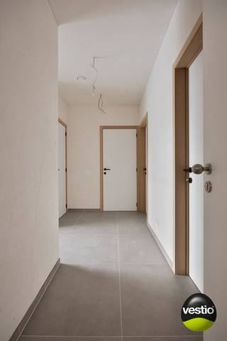 Een unieke kans die je niet mag missen!<br />Dit strakke nieuwbouwappartement in Munsterbilzen combineert modern wooncomfort met een uitzonderlijk fiscaal voordeel: jij betaalt slechts 2% registratierechten in plaats van 21% btw — een besparing van tienduizenden euro's. Nog nooit bewoond, instapklaar en toekomstgericht. Of je nu een eigen thuis zoekt of slim wil investeren: dit is je kans.<br />Licht, ruimte en kwalitatieve afwerking<br /><br />Zodra je binnenstapt, valt de lichtrijke leefruimte op met grote raampartijen en een naadloze verbinding met het ruime terras aan de achterzijde — perfect voor een ontspannen avond buiten of een gezellige loungehoek. Warme parketlook-tegels en een strakke, tijdloze afwerking maken de sfeer meteen compleet.<br />De volledig ingerichte open keuken is uitgerust met nieuwe toestellen en biedt ruim voldoende kastruimte. Aansluitend vind je een handige berging met technische installaties en aansluiting voor een wasmachine.<br /><br />De badkamer met inloopdouche en dubbele lavabo straalt kwaliteit uit, en de twee volwaardige slaapkamers bieden alle ruimte die je nodig hebt — voor een gezin, een koppel, of als rendabele investering.<br /><br />Kleine opmerking, groot voordeel: het appartement wordt opgeleverd zonder schilderwerken — de muren zijn klaar om te schilderen. Dat klinkt misschien als een werkpunt, maar het is eigenlijk een troef: jij kiest zelf de kleuren en maakt het appartement van meet af aan helemaal van jou. Geen overschilderen van andermans smaak, maar een frisse start met jouw eigen touch.<br /><br /><strong>Indeling</strong>
<ul>
<li>Inkomhal met vestiaire en gastentoilet</li>
<li>Lichtrijke leefruimte met open keuken</li>
<li>Volledig ingerichte keuken met nieuwe toestellen</li>
<li>Berging (technieken + wasaansluiting + opbergruimte)</li>
<li>2 volwaardige slaapkamers</li>
<li>Badkamer met inloopdouche en dubbele lavabo</li>
<li>Ruim terras aan de achterzijde</li>
<li>Privatieve parkeerplaats + kelderberging inbegrepen in de prijs</li>
</ul>
<br /><strong>Energiezuinig wonen op zijn best</strong><br />Met een E-peil van E19 behoort dit appartement tot de absolute top op vlak van energieprestaties. Vloerverwarming via warmtepomp, zonnepanelen en een hoogwaardig ventilatiesysteem zorgen voor een laag energieverbruik en lage maandelijkse kosten. Investeren in de toekomst was nog nooit zo verstandig.<br /><br /><strong>Jouw voordelen in een oogopslag</strong><br />✅ Nooit bewoond — écht instapklaar<br />✅ Slechts 2% registratierechten<br />✅ BEN-appartement (E19)<br />✅ Zonnepanelen & warmtepomp<br />✅ Lift in het gebouw<br />✅ Ruim terras & privatieve parking inbegrepen<br />✅ Kelderberging inbegrepen<br />✅ Vermindering kadastraal inkomen eerste 5 jaar<br /><br />Interesse? Neem vandaag nog contact op!<br />Wil je dit appartement bezoeken of heb je vragen? Wij helpen je graag verder en plannen snel een afspraak in. Neem contact op met 0478 30 04 25 of michiel@vestio.com<br /><br />Overweeg je om te verkopen, of ben je gewoon benieuwd naar de huidige waarde van je woning? Wij maken vrijblijvend en kosteloos een professionele schatting op maat — zonder verplichtingen achteraf.