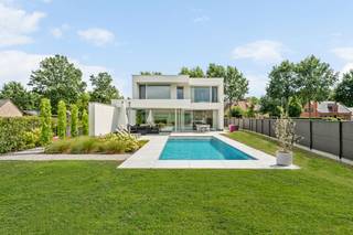 This modern and energy-efficient villa is located in a quiet and centrally located street in Lommel. This property dates from 2022 and is finished with high-quality materials. The villa includes a beautiful living space with a sitting area, dining area, and fitted kitchen, a multifunctional space, storage cellar, basement, 3 bedrooms, 2 bathrooms, 2 guest toilets, a swimming pool, and an attached carport for 2 cars.<br /><br />Ground floor:<br />You enter the house through the entrance hall with a separate toilet that directly overlooks the garden. The living room and kitchen are bathed in daylight through the large windows at the rear of the house. These spaces seamlessly connect but still feel cozy due to the thoughtful architecture.<br /><br />The modern kitchen is fully equipped with high-quality appliances and has plenty of cupboard space. Adjacent to the kitchen is a practical storage room that serves as the entrance to the carport.<br /><br />First floor:<br />The master bedroom consists of a spacious bedroom overlooking the garden. Opposite is the impressive bathroom with a walk-in shower, double sink, and freestanding bath. There are also 2 additional bedrooms, currently used as a dressing room and laundry room. The toilet is provided separately.<br /><br />Basement:<br />On the lower floor, we find the multifunctional space for a hobby room, sports room, office, or additional bedroom. Adjacent is the second bathroom with a sauna, sink, and walk-in shower. There is also a storage room and cellar. The basement area is also accessible through an outside door.<br /><br />Garden:<br />The garden is completely fenced and equipped with a beautiful swimming pool. At the front of the house, there is a carport for parking 2 cars.<br /><br />Extraordinary features:<br />- Underfloor heating<br />- Swimming pool<br />- Multifunctional space<br />- Air conditioning<br />- Carport for 2 cars