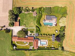 Prachtig gelegen eigendom op een uitzonderlijke locatie met adembenemende verzichten (mogelijkheid overname aandelen). Verscholen in alle rust en bereikbaar via een statige, lange toegangsdreef bevindt zich dit uitzonderlijke eigendom op een perceel van maar liefst 5.721 m². Een zeldzame locatie waar privacy, natuur en ruimte naadloos samenkomen.De unieke ligging biedt panoramische verzichten over het omliggende landschap en creëert een oase van rust, terwijl u toch geniet van een vlotte bereikbaarheid. Dit is een eigendom met karakter en vooral met een enorm toekomstpotentieel. Ideaal als B&B/wellness. Dankzij de royale perceeloppervlakte en de veelzijdige mogelijkheden leent deze eigendom zich perfect voor wie op zoek is naar een exclusieve woonst, een combinatie van wonen en werken, natuur of een project waarbij ruimte en ligging centraal staan.Charmante fermette - gelijkvloers wonen, extra B&B-gedeelte, wellness met sauna, en zwembad (overkapping mogelijk); extra charmant bijgebouw (voorzien van zonnepanelen) met zwemvijver, carport en tuinhuis, prachtige tuin en toegangsweg. Bent u op zoek naar een unieke locatie waar u uw eigen visie kunt realiseren? Dan is dit zonder twijfel een buitenkans.Bezoek na afspraak met IMMO BEGUIN: flore@immobeguin.be