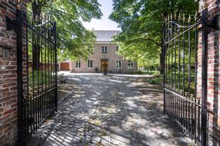 Wie op zoek is naar ruimte, rust en veelzijdigheid, voelt zich hier meteen thuis. Deze uitzonderlijke vrijstaande woning is gelegen op een prachtig perceel van maar liefst 8.392 m² en combineert royale volumes met privacy, comfort en een uniek groen kader.<br /><br />De woning wordt omgeven door een schitterende, volwassen en perfect georiënteerde zuidgerichte tuin, waar je in alle rust geniet van zon, natuur en een weids uitzicht op het omliggende groen. De ruime oprit en garage zorgen bovendien voor optimaal praktisch comfort en voldoende parkeergelegenheid.<br /><br />Binnen verwelkomt de woning je met bijzonder royale leefvolumes en een doordachte indeling. <br />De woning beschikt over 4 bijzonder ruime slaapkamers, elk met veel lichtinval en tal van indelingsmogelijkheden. De badkamer is volledig uitgerust en biedt alle comfort met zowel een ligbad als een douche.<br /><br />Een extra troef is de ruime zolderverdieping, bereikbaar via een vaste trap. Deze polyvalente ruimte biedt nog tal van mogelijkheden en kan perfect ingericht worden als extra slaapkamers, hobbyruimte, bureau of ontspanningsruimte.<br /><br />De inpandige dubbele garage heeft nog een bijkomende zolder die ook nog volledig ingericht kan worden. <br /><br />Naast het hoofdgebouw is er nog een bijgebouw dat volledig voorzien is van keuken en badkamer en mogelijkheid bied voor uitbreiding van 1 naar 3 slaapkamers. <br /><br />Dit eigendom biedt een uitzonderlijke flexibiliteit en is ze uitermate geschikt voor cohousing, kangoeroewonen, een praktijk aan huis of het comfortabel samenwonen van meerdere generaties.<br /><br />Daarnaast biedt deze woning ook energetisch nog interessante opportuniteiten: met een beperkte investering kan het EPC aanzienlijk verbeterd worden. Bij de plaatsing van een warmtepomp en het verwijderen van de houtkachel kan de EPC-score stijgen naar begin label B, wat een mooie meerwaarde betekent voor de toekomstige eigenaar.<br /><br />Contacteer Vincent voor een bezoek ter plaatse via 0475 21 00 86 of Vincent@reds.be.