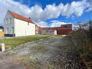 Een uitzonderlijke bouwkans op een bijzonder rustige ligging, en dat pal in het centrum van Lauwe.<br /><br />Dit L-vormige perceel van 403 m² ligt verscholen in een rustige straat en vormt de basis voor een verrassend en bijzonder knap woonproject. De architect wist de specifieke vorm van het perceel optimaal te benutten en ontwierp een karaktervolle woning waarin ruimte, licht, privacy en wooncomfort centraal staan.<br /><br />De omgevingsvergunning voor het project werd reeds toegekend en de volledige architectuurplannen en renders zijn beschikbaar. Een belangrijk voordeel voor wie niet van nul wil beginnen: het voorbereidende traject is al doorlopen en het vergunde project kan verder worden gerealiseerd.<br /><br />Het ontwerp combineert een tijdloze architectuur met een bijzonder praktische indeling. Aan de straatzijde bevindt zich een ruime inpandige garage, terwijl de woning zich verder over het perceel ontvouwt. Grote raampartijen zorgen voor veel natuurlijk licht en creëren een mooie verbinding met de tuin en de verschillende terrassen.<br /><br />Op het gelijkvloers voorziet het plan onder meer in een ruime inkomhal, technische ruimte, garage, een royale open leefruimte met zithoek, eetplaats en keuken met eiland. Daarnaast werd hier ook een volwaardige slaapvleugel voorzien met slaapkamer, dressing en badkamer. Hierdoor is comfortabel wonen op het gelijkvloers perfect mogelijk.<br /><br />Op de verdieping bevinden zich een tweede slaapkamer, een tweede badkamer, een ruime bureauruimte en bijkomende zolderruimte. Het resultaat is een woning met een heel eigen karakter, waarin de beschikbare oppervlakte bijzonder efficiënt wordt benut.<br /><br />Ook buiten werd veel aandacht besteed aan privacy en groen. Door de bijzondere vorm van het perceel ontstaan verschillende beschutte buitenruimtes en een aangename tuin rondom de woning.<br /><br />Momenteel bevindt zich op een deel van het perceel nog een bouwvallige constructie. De huidige foto's tonen de bestaande toestand; de renders geven een mooi beeld van het vergunde toekomstproject.<br /><br />En dan is er nog de ligging: rustig wonen en toch werkelijk alles binnen handbereik. Winkels, scholen, openbaar vervoer en andere dagelijkse voorzieningen bevinden zich op wandelafstand. Direct naast het perceel ligt bovendien een speelpleintje, een mooie extra troef voor gezinnen.<br /><br />Een bijzonder perceel, een reeds toegekende vergunning én een prachtig uitgewerkt architecturaal concept: een unieke kans om in het centrum van Lauwe een woning met uitstraling en karakter te realiseren.