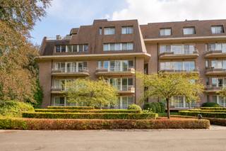 Ruim en lichtrijk appartement van ca. 150 m², gelegen in een bijzonder aangename en groene omgeving. Dankzij de royale volumes, grote raampartijen en het ruime overdekte terras geniet het appartement van een open, rustige sfeer en een prachtig zicht op het omliggende groen.<br /><br />Bij het binnenkomen komt u terecht in een ruime inkomhal met afzonderlijk gastentoilet en handenwasser.<br /><br />De ruime leefruimte biedt plaats aan zowel een comfortabele zithoek als een volwaardige eetkamer. De parketvloer en open haard zorgen voor extra karakter en warmte, terwijl de grote raampartijen voor een overvloed aan natuurlijk licht zorgen.<br /><br />De vernieuwde keuken is modern en strak ingericht, met veel bergruimte en ingebouwde toestellen. <br /><br />Het appartement beschikt over twee ruime slaapkamers. De eerste slaapkamer heeft een eigen badkamer met douche. De masterbedroom beschikt over een dressing en een grote, vernieuwde badkamer met ligbad, inloopdouche en dubbele lavabo.<br /><br />Een van de grote troeven is zonder twijfel het ruime, overdekte terras, waar u in alle rust kunt genieten van het open zicht op de verzorgde en groene omgeving. <br /><br />Ook op technisch vlak werden verschillende verbeteringen uitgevoerd, waaronder vernieuwingen aan de elektrische installatie, verlichting, bekabeling en stopcontacten. Daarnaast is het appartement uitgerust met luchtwarmtepompen/airconditioning in meerdere ruimtes. Ook de ramen werden vernieuwd en zijn voorzien van vliegenramen. <br /><br />Het appartement beschikt bovendien over één autostaanplaats en één berging.<br /><br />Kortom, een zeer ruim en comfortabel appartement met veel lichtinval, een groene ligging, een ruim terras en tal van reeds uitgevoerde renovaties.<br /><br />Het appartement is beschikbaar ca. begin november 2027. <br /><br />Het prachtige parkdomein 'De Wilaard' wordt gekenmerkt door zijn unieke stilte, rust, vijvers en prachtige bomenbestand. Het domein van ca 12ha is altijd perfect onderhouden en straalt een adembenemende schoonheid uit, het ganse jaar door. Desondanks zijn rustige ligging geniet het domein toch een uitstekende bereikbaarheid met het centrum en station van Kapellen op slechts 5 minuten wandelen. Ook alle voorzieningen, invalswegen en openbaar vervoer bevinden zich op een boogscheut.<br />Een buitengewone kans om te wonen in een luxueus appartement in de uiterste rust.