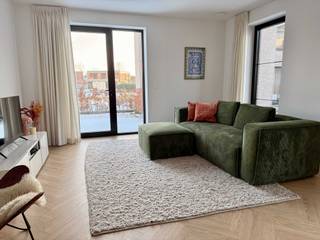 Dit nieuwbouwappartement is gelegen in een rustige woonwijk te Hoogstraten, op wandelafstand van het centrum. Het appartement bevindt zich op het gelijkvloers en heeft een bewoonbare oppervlakte van 93 m², de kelder is bereikbaar met de gemeenschappelijke lift.<br /><br />Het appartement beschikt over een lichtrijke leefruimte met aansluitend een open keuken.<br />De keuken is volledig uitgerust met onder andere een vaatwasser, oven en ingebouwde koelkast.<br />Aansluitend aan de keuken bevindt zich een praktische berging.<br /><br />Verder zijn er twee slaapkamers, een badkamer met douche en een apart toilet.<br /><br />Het appartement is voorzien van:<br />- Dubbel glas<br />- Vloerverwarming<br />- Collectieve centrale verwarming op gas<br />- Ventilatiesysteem D<br />- Zonnepanelen<br />- EPC-score A<br />Dit zorgt voor een aangenaam wooncomfort en een energiezuinig verbruik.<br /><br />Aan de buitenzijde beschikt het appartement over twee terrassen (beide 8 m²) en een privétuin, ideaal om rustig te genieten.<br />Daarnaast hoort er een ondergrondse staanplaats met aanliggende berging bij het appartement.<br /><br />Praktische informatie<br />- Huurprijs: €1.350/maand<br />- Gemeenschappelijke kosten: €140/maand (onderhoud gemeenschappelijke delen + collectieve verwarming op gas)<br />- Huurwaarborg: 3 maanden<br />- Beschikbaar vanaf maart 2026<br /><br />Interesse? Neem gerust contact op voor bijkomende informatie of een bezichtiging.