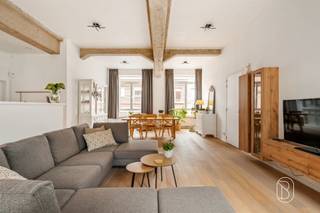 Prachtige instapklare gelijkvloerse loft van 240 m² met ruim terras en parkeerplaats!Gelegen in Ruien, aan de voet van de prachtige Vlaamse Ardennen, bevindt zich deze uitzonderlijk ruime en perfect onderhouden gelijkvloerse loft. Met een bewoonbare oppervlakte van maar liefst 240 m², indrukwekkende plafondhoogtes van 3,30 m en een prachtig terras van 40 m² geniet u hier van een unieke combinatie van ruimte, licht en comfort.Via de inkomhal met gastentoilet bereikt u de royale en lichtrijke leefruimte met open keuken, waar de hoge plafonds zorgen voor een uitzonderlijk ruimtegevoel. Verder beschikt de loft over 3 volwaardige slaapkamers, een comfortabele badkamer met zowel ligbad als douche en een praktische berging.Een absolute extra troef is de halfondergrondse verdieping van maar liefst 60 m². Deze multifunctionele ruimte biedt tal van mogelijkheden als hobbyruimte, wellness met sauna, ontspanningsruimte of extra bergruimte.Buiten geniet u van een heerlijk terras van 40 m², waarvan een gedeelte overdekt is. Daarnaast zijn er 2 private parkeerplaatsen beschikbaar.Dankzij de zonnepanelen van 3.900 W en het uitstekende EPC-label A (78 kWh/m²) geniet u bovendien van een bijzonder energiezuinige eigendom. Er is geen syndicus; enkel het dak en de gevels zijn gemeenschappelijk.De loft is verhuurd sinds 1 juni 2023 en genereert momenteel een maandelijkse huurinkomst van € 1.006,38. Hierdoor vormt deze eigendom ook voor investeerders een interessante opportuniteit. Ideaal voor wie op zoek is naar een uitzonderlijk ruime, instapklare en energiezuinige loft met tal van mogelijkheden, of voor investeerders die een unieke eigendom met bestaande huurinkomsten wensen.Vraagprijs: € 425.000, inclusief één parkeerplaats. Een tweede parkeerplaats kan mee opgenomen worden in de onderhandelingen.Meer info of een bezoek via emmy@immobeguin.beTe koop via Immo Beguin, jouw vastgoedexpert sinds 2009, met kantoren in Ronse, Waregem, Kortrijk, Deinze, Doornik, Lessines, Moeskroen en Nieuwpoort.