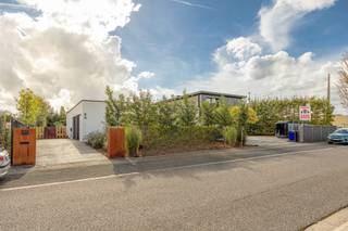 Deze gelijkvloerse villa in Aartselaar ligt op een perceel van 1.593 m² en combineert een ruime woning met een groot magazijn. De woning heeft een open indeling, grote glaspartijen en veel natuurlijk licht.<br /><br />Via de inkomhal met grote glazen deur kom je binnen in de woning. Hier bevinden zich een ingemaakte vestiaire en een gastenwc met smart-toilet. De ruime eetkamer sluit aan op de woonkamer met zicht op de tuin. De volledig uitgeruste keuken is voorzien van inbouwtoestellen en sluit aan op een technische berging.<br /><br />De master bedroom beschikt over een geïntegreerde badkamer met ligbad en dubbele regendouche én een volledig ingebouwde dressing met wasruimte. De tweede slaapkamer heeft eveneens een eigen badkamer met douche.<br /><br />Verder beschikt de woning over vloerverwarming, domotica, geïntegreerd geluidsysteem en een conforme elektrische installatie.<br /><br />Buiten is er een aangenaam terras en een volwassen, groen aangelegde tuin (zwembad mogelijk). Aan de woning is er een oprit met plaats voor drie wagens en een laadpaal.<br /><br />Naast de villa bevindt zich het ruime magazijn, voorzien van een toilet en douche. Het magazijn beschikt ook over een verdieping, wat extra opslag- of werkruimte biedt. De ruime oprit (circa 180m²) aan het magazijn zorgt voor voldoende manoeuvreerruimte.<br /><br />Extra troeven:<br />- Gelijkvloerse villa<br />- Perceel van 1.593 m²<br />- Ruim magazijn met verdieping<br />- Ruime oprit aan het magazijn<br />- Oprit aan de woning voor drie wagens<br />- Laadpaal<br />- Twee slaapkamers met elk een eigen badkamer<br />- Grote glaspartijen<br />- Aangename tuin en terras<br />- Mogelijkheid tot zwembad<br />- Vloerverwarming<br />- Domotica<br />- Surround geluidssystemen<br />- Conforme elektrische installatie<br />- 20 zonnepanelen<br />- EPC A (BEN-woning met E-peil van 21)<br />- Enkele jaren vrijgesteld van onroerende voorheffing<br />- Aanwezige camerabewaking, zonder abonnement<br /><br />Graag meer info of een bezoek gewenst?<br />Contacteer ons via 0492 83 88 19 of jarno@groepvanhaute.be