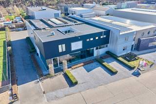 Bedrijfsgebouw van 720m² op een perceel van 1276m² gelegen op de "KMO-zone Molenheide" in Zonhoven. Deze kleinschalige bedrijvenzone is volledig omgeven door de groene omgeving "De Teut" en ligt slechts op 4km van de E314. Dit gebouw bestaat uit een toonzaal met kantoren, een werkruimte/atelier en een magazijn. Verder is er op de verdieping een volledig instapklare conciërgewoning met een mooi terras. Het gebouw is voorzien van zonnepanelen (10WP), een warmtepomp en is er waterrecuperatie voorzien. Achter het gebouw is er een verhard buitenterrein van 335m². <br /><br />KENMERKEN HAL:<br />- oppervlakte: 285m²<br />- vrije hoogte: 7m<br />- stalen constructie met geïsoleerde sandwichpanelen en steeldeck met lichtstraat<br />- elektrische sectionaalpoort<br /><br />KENMERKEN SHOWROOM - KANTOOR:<br />- oppervlakte: 220m² <br />- indeling: showroom, kantoren, sanitaire cel, refter en werkruimte<br />- veel lichtinval door de rote glasgevel<br />- voorzien van al het hedendaags comfort: zonnepanelen, airco, data-netwerk <br /><br />KENMERKEN CONCIËRGEWONING - APPARTEMENT:<br />- oppervlakte: 200m² + 20m² terras<br />- indeling: ruime woonkamer met open keuken, 2 slaapkamers waarvan één met een dressing, badkamer, berging, inkom en terras<br />- volledig instapklaar met een mooie industriële afwerking<br /><br />TROEVEN:<br />- multifunctioneel gebouw met zeer mooi appartement<br />- zonnepanelen (10WP) met groene stroomcertificaten van 280€/stuk tot 2032<br />- elektriciteitsaansluiting: 380V / 80A<br />- volledig instapklaar