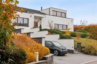 Gelegen op een onderhoudsvriendelijk terrein van 1.029 m² in een doodlopende straat bevindt zich deze moderne villa. De woning werd in 2019 smaakvol gerenoveerd en voldoet ondertussen aan de energiedoelstelling van 2050. <br /><br />De bewoonbare oppervlakte van 480 m² is als volgt ingedeeld:<br /><br />0: Inkomhal met gastentoilet, ruime woon- en eetkamer voorzien van open haard en onmiddellijke toegang tot het overdekte terras, volledig uitgeruste open keuken. Drie slaapkamers (16, 9 en 9 m²) met badkamer voorzien van wastafel, toilet en douche, en een mastersuite (18 m²) voorzien van dressing en badkamer met dubbele wastafel, douche en ligbad.<br /><br />+1: de bovenverdieping kan dienen als ontspanningsruimte/bureel met ruim terras of kan verder ingericht worden tot 2 slaapkamers met badkamer (leidingen aanwezig).<br /><br />-1: de kelderverdieping omvat een dubbele garage (achter elkaar), een voorraadruimte en technische ruimte. De rest van de woning is voorzien van een kruipkelder.<br />De buitenomgeving (zuidoost georiënteerd) is onderhoudsvriendelijk en wordt gekenmerkt door een overdekt terras, buitendouche, een tuinhuis en een ruime oprit.