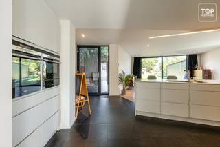 Deze ruime en veelzijdige woning combineert comfortabel wonen met heel wat extra mogelijkheden voor werk, hobby en opslag. Dankzij de praktische indeling, de grote loods en de ruime tuin is dit een eigendom met heel wat mogelijkheden.<br /><br />Binnen beschikt de woning over een ruime inkomhal met veel kastruimte, een aangename leefruimte en een open keuken voorzien van alle comfort. Vanuit de leefruimte geniet u van een mooi zicht op de tuin. Aansluitend is er een eethoek met toegang tot de bureauruimte en een badkamer op het gelijkvloers.<br /><br />Op de bovenverdieping bevinden zich 3 slaapkamers en een tweede badkamer. De woning werd gerenoveerd in 2015 en biedt heel wat comfort. Twee slaapkamers kunnen nog volledig naar eigen smaak worden afgewerkt. Daarnaast beschikt de woning over zonnepanelen en airconditioning. Een 4de slaapkamer kan worden ingericht. <br /><br />Een absolute troef is de grote loods/het magazijn met daglicht en toilet. Dankzij de zijingang is deze ruimte makkelijk bereikbaar en ideaal voor een zelfstandige of hobbyist, opslag of het stallen van een wagen of aanhangwagen.<br /><br />Troeven:<br /><br />2 badkamers, waarvan één op het gelijkvloers<br />Grote loods/magazijn met daglicht en toilet<br />Handige zijingang<br /><br />Grote zonnige tuin met veel privacy<br />3 terrassen<br />Bureauruimte op het gelijkvloers<br />Zonnepanelen met groenestroomcertificaten tot 2031.<br />Airconditioning<br />Kelder en zolder<br />Gerenoveerd in 2015<br />Instapklaar met nog mogelijkheden tot verdere afwerking<br /><br />Beschikbaar bij akte!<br /><br />Contacteer Top Vastgoed voor een bezoek: 0475 700 700.