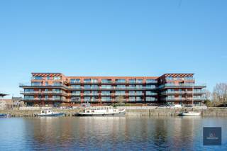 Dit stijlvolle appartement in Gent met twee slaapkamers is gebouwd in het jaar 2020. Het heeft een bewoonbare oppervlakte van 96m² en heeft een mooi terras dat over het water (voorhaven) kijkt. <br /><br />Het appartement is modern en licht ingericht en is voorzien van alle gemakken. De open keuken is voorzien van alle benodigde apparatuur en er is voldoende ruimte om gezellig te kunnen dineren. De woonkamer is ruim en heeft grote ramen die zorgen voor veel natuurlijk lichtinval. <br /><br />De twee slaapkamers zijn beide ruim en bieden voldoende opbergruimte. De badkamer is modern en voorzien van een bad met douchemogelijkheden en een dubbele wastafel. Het toilet is weg van de badkamer. <br /><br />Bij dit appartement hoort een ondergrondse, ruime staanplaats en een kelder. <br /><br />Het appartement is gelegen in een rustige buurt in Gent en heeft een goede verbinding met het openbaar vervoer en de snelweg. Daarnaast zijn er ook diverse winkels, restaurants en andere voorzieningen in de directe omgeving.<br /><br />Kortom, dit appartement is een ideale woning voor een klein gezin of een stel dat op zoek is naar een moderne en comfortabele woning in Gent.