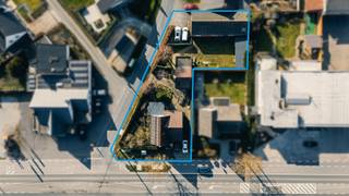 Alleenstaande woning met loods en bijhuis op 1073m² te Torhout.<br /><br />Deze stevig gebouwde woning langs de Roeselaarseweg staat te koop. Het betreft een hoekperceel met achteraan een ruime loods, centraal bijhuis en langs de voorzijde een stevige woonst.<br /><br />De woning:<br /><br />Bevat een oprit, inkom en ruimte leefruimte. Deze living heeft een speksteenkachel, grote raampartijen en is voldoende groot voor bureau en TV hoek. Achteraan de woning is er een open keuken met ontbijthoek. Ook hier staat hun grote tafel en kunnen vele mensen plaats nemen.<br />Verder is er op het gelijkvloers nog een kamer, momenteel naaikamer. En toegang tot de kelder. Het verdiep bevat 3 echt ruime slaapkamers en een bureaukamer. Ook is er een vernieuwde badkamer.<br /><br />Bijhuis:<br /><br />Deze is recentelijk gerenoveerd en up to date! Van deze is er een video terug te vinden op onze site. Ingerichte keuken, grote kelder, badkamer, toilet, eigen aparte inkom, verdiep met grote slaapkamer (heel wat inmaakkasten) en dressing/kinderkamer. Ideaal voor de bijberoeper, kangoeroewoning, praktijk, tijdelijke verhuur,..<br />Loods:<br /><br />Deze is voorzien van een vlakke betonvloerplaat, hoge poort, zware elektriciteit (3x400v),… Deze is 8.01m breed en 19.01 m diep. Verder heeft deze nog een oprit met parkeerplaats.<br /><br />PLUSPUNTEN:<br />+ commerciële ligging<br />+ Vele zonnepanelen<br />+ loods & bijhuis