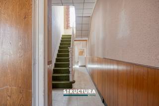 In een eenrichtingsstraat en met centrale ligging te Wemmel, nabij Relegem, vinden we deze charmante woning met een mooi perceel van 4a05ca. Deze eigendom biedt een uitstekende opportuniteit voor wie op zoek is naar een renovatieproject met karakter en potentieel. De zuidoost georiënteerde tuin vormt een absolute troef.IndelingDe woning omvat op het gelijkvloers een inkomhal, een ruime leefruimte en een aparte keuken met aansluitend de badkamer. Achteraan geniet u van zicht en toegang tot de tuin.Op de eerste verdieping bevinden zich twee volwaardige slaapkamers en een nachthal.Verder beschikt de woning over een zolderruimte, die mogelijkheden biedt tot extra inrichting, alsook een kelder met praktische bergruimte. Buiten zijn er bijkomende bergingen aanwezig.Karakteristieken- Te renoveren woning met authentieke elementen- Perceeloppervlakte: 4a05ca- Zuid-oost georiënteerde tuin- Centrale ligging in Wemmel, nabij Relegem- Twee slaapkamers + uitbreidingsmogelijkheden via de zolder- Kelder en buitenbergingen aanwezig- Bestuursmaatregelen in het maatregelenregister: nee- EPC F, aldus renovatieplicht binnen 6jDeze woning is ideaal voor handige kopers of investeerders die op zoek zijn naar een project met potentieel op een gegeerde locatie. Mits de nodige renovatiewerken kan deze eigendom worden omgevormd tot een warme thuis, volledig naar eigen smaak en normen. Contacteer ons vandaag nog voor meer informatie of een bezoek ter plaatse via 02 460 80 46 of info@structura.be