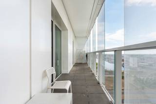 Dit lichtrijke appartement met zonneterras bevindt zich op de 13de verdieping van De Parktoren, een doordachte creatie van BESIX die bekroond werd met de Architizer A+ Award. Het gebouw ligt op een toplocatie nabij het Eilandje, naast Park Spoor Noord en de AP Hogeschool.
De locatie is ideaal voor eigen bewoning of als investering: omgeven door groen, met tal van horecazaken in de buurt en een vlotte bereikbaarheid dankzij het openbaar vervoer.
Het appartement biedt een lichtrijke leefruimte met open keuken, uitgerust met ingebouwde toestellen zoals een kookplaat met dampkap, combi-oven, koelkast en een roestvrijstalen spoelbak. De moderne badkamer beschikt over een inloopdouche, wastafel en toilet. Verder zijn er twee ruime slaapkamers en een handige bergruimte die ook als wasplaats kan dienen. Het zonneterras biedt een indrukwekkend uitzicht over de stad.
Er is de mogelijkheid om een ondergrondse parkeerplaats aan te kopen voor 28.000 euro.
De Parktoren is uitgerust met geavanceerde systemen voor ventilatie, isolatie, akoestiek en wind- en vochtigheidsbeheer. Dankzij de slimme constructie wordt er optimaal gebruikgemaakt van natuurlijk daglicht, wat het wooncomfort nog verhoogt.