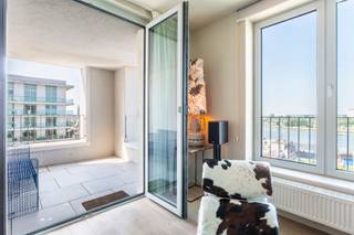 <p>Het oudste havengebied van Antwerpen, ’t Eilandje, heeft doorheen het ganse jaar zowel een vakantie als thuisgevoel. Door water omgeven en toch op 5 minuten in het centrum van ’t Stad. Wat wil je nog meer? <br /><br />Op de 14de verdieping van residentie “Westkaai 71” bevindt zich dit recent appartement van ca. 82 m², waar sereniteit en comfort harmonieus samenkomen. Dankzij de doordachte indeling en de grote raampartijen geniet het appartement van een aangename lichtinval en een ruimtelijk gevoel. Doorheen het volledige appartement werd gekozen voor een hoogwaardige parketvloer, wat zorgt voor een warme en stijlvolle uitstraling.</p>
<p>Wanneer we in de leefruimte terechtkomen zal u omvergeblazen worden van de magnifieke zichten over de Scheldebocht en de stad Antwerpen. Unieke zichten over unieke locaties, vanop het terras welke toegankelijk is vanuit de leefruimte.<br /><br />De op maat gemaakte keuken is geïnstalleerd met kwalitatieve toestellen en heeft een fijn contact met de leefruimte. Hiernaast vinden we een handige berging terug welke voorzien is van aansluitingen voor een wasmachine en droogmachine.<br /><br />Twee volwaardige slaapkamers delen een moderne badkamer voorzien van een douche in bad en een dubbele wastafel met opbergkasten.<br /><br />Een praktische kelderberging is inbegrepen in de prijs en biedt extra opbergruimte. Daarnaast bestaat de mogelijkheid om drie ondergrondse parkeerplaatsen aan te kopen aan € 37.300/stuk.</p>
<p>Je eigen uitkijkpost over de stad Antwerpen en de Schelde?<br />Kom deze samen met ons ontdekken, contacteer LISTED: +32 3 283 51 51.</p>