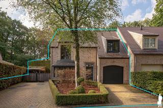 <p><strong><span>Stijlvolle koppelvilla met 5 slaapkamers en prachtige tuin op ca. 1.033 m² in exclusief afgesloten woondomein "Dennenburg"!</span></strong></p>
<p><span>Deze sfeervolle </span><strong><span>koppelvilla</span></strong><span> combineert royale woonvolumes met een bijzonder groene woonomgeving. Met </span><strong><span>5 slaapkamers, 2 badkamers, een inpandige garage</span></strong><span> en een indrukwekkende leefkeuken biedt de woning alle ruimte voor comfortabel gezinsleven. Grote raampartijen zorgen voor veel licht en een prachtige tuinconnectie.</span></p>
<p><strong><span>Gelijkvloerse verdieping</span></strong><br /><span>- </span><strong><span>Inkomhal</span></strong><span> met ingemaakte vestiairekasten en gastentoilet</span><br /><span>- Royale </span><strong><span>woon- en eetkamer</span></strong><span> op parket met grote raampartijen en maatwerk</span><br /><span>- Ruime </span><strong><span>leefkeuken</span></strong><span> met kook- en spoeleiland en veel bergruimte</span><br /><span>- Aparte eetruimte met zicht op de tuin</span><br /><span>- Hoge houten plafondstructuur en grote glaspartijen</span><br /><span>- Rechtstreekse toegang tot terras en tuin</span><br /><span>- Afzonderlijk </span><strong><span>bureau</span></strong><span> met maatwerk</span><br /><span>- Toegang tot de </span><strong><span>inpandige garage</span></strong></p>
<p><strong><span>Eerste verdieping</span></strong><br /><span>- Nachthal</span><br /><span>- Verschillende ruime slaapkamers</span><br /><span>- </span><strong><span>Mastergedeelte met royale dressing. Badkamer met ligbad en dubbele wastafel</span></strong><br /><span>- Badkamer met </span><strong><span>inloopdouche en lavabomeubel</span></strong></p>
<p><strong><span>Tweede verdieping</span></strong><br /><span>- Ruime slaapkamer onder het dak met zichtbare balken</span><br /><span>- Eveneens geschikt als hobby- of werkruimte</span></p>
<p><strong><span>Tuin en buitenruimte</span></strong><br /><span>- Perceel van ca. </span><strong><span>1.033 m²</span></strong><br /><span>- </span><strong><span>Zuidwestgerichte</span></strong><span>, fraai aangelegde tuin</span><br /><span>- Veel groen en privacy dankzij volwassen bomen en hagen</span><br /><span>- Ruim terras en royale gazonpartijen</span><br /><span>- Oprit met parkeergelegenheid</span></p>
<p><strong><span>Garage en berging</span></strong><br /><span>- </span><strong><span>Inpandige garage</span></strong><br /><span>- Praktische berging en zolderruimte</span></p>
<p><strong><span>Bijzonderheden</span></strong><br /><span>- </span><strong><span>5 slaapkamers en 2 badkamers</span></strong><br /><span>- Veel maatwerk en ingemaakte kasten</span><br /><span>- Apart bureau</span><br /><span>- Verwarming op aardgas</span><br /><span>- EPC </span><strong><span>187 kWh/m² – label B</span></strong><br /><span>- Exclusief </span><strong><span>afgesloten woondomein</span></strong></p>
<p><strong><span>Ligging</span></strong><br /><span>Gelegen</span><span> binnen het exclusief afgesloten woondomein </span><strong><span>Dennenburg</span></strong><span>. Een groene en residentiële omgeving met veel rust en privacy, op vlotte afstand van winkels, scholen en dagelijkse voorzieningen. Ook Kapellen en Kalmthout zijn vlot bereikbaar.</span></p>
<p><strong><span>Een stijlvolle gezinswoning met royale woonvolumes en een prachtige tuin binnen een exclusieve, groene woonomgeving.</span></strong></p>