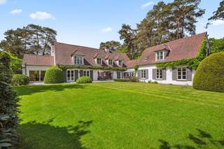Deze exclusieve landelijke villa, ontworpen door architect Leo Beeck, ligt in een rustige straat nabij het meer van Keerbergen. Ze bevindt zich op een prachtig aangelegd domein van 3.870 m² en biedt ongeveer 600 m² bewoonbare oppervlakte — een perfecte combinatie van elegantie, comfort en privacy.<br /><br />U wordt verwelkomd in een ruime inkomhal met gastentoilet en vestiaire. De leefruimtes lopen vloeiend in elkaar over, met een luxueuze open keuken uitgerust met topapparatuur van V-ZUG en Lacanche, inclusief gas- en elektrische kookplaat, stoomoven, koffiemachine, vaatwasser en meer. Een geavanceerd filtersysteem voorziet in zuiver drinkwater, los van de centrale installatie.<br /><br />De lichtrijke eetkamer met gashaard biedt prachtig zicht op de tuin en sluit aan op de sfeervolle woonkamer, bibliotheek en bureau – elk met eigen gashaard (in totaal 3). Voor ontspanning zijn er een tv-kamer, fitnessruimte, traditionele én infraroodsauna.<br /><br />Op de eerste verdieping bevinden zich vier ruime slaapkamers met maatwerk. De master bedroom heeft een inloopdressing, eigen badkamer met ligbad en inloopdouche, en een beveiligde deur. Verder zijn er nog een extra badkamer en aparte doucheruimte.<br /><br />Daarnaast is er een volledig uitgeruste studio met woonkamer, slaapkamer, kitchenette en badkamer – ideaal als gastenverblijf.<br /><br />De volledig omheinde tuin beschikt over twee automatische poorten, een irrigatiesysteem en buitenkranen aangesloten op een eigen waterput. De woning heeft ook een dubbele garage, alarmsysteem en een hoogwaardige afwerking. Een unieke eigendom die luxe en rust verenigt.<br /><br />*mogelijke overname van inboedel*