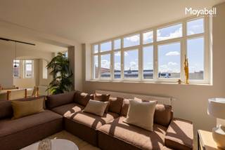 'PRADO' The Penthouse <br />PRADO PENTHOUSE biedt een unieke woonervaring midden in het historische hart van Gent, op slechts 300 meter van de Kouter. Dit luxueuze appartement van 160 m² bevindt zich in een karaktervol gebouw uit 1925, opgetrokken in neoclassicistische stijl, waar authentieke elementen naadloos samensmelten met hedendaags comfort en functionaliteit. De op maat ontworpen keuken met kookeiland is afgewerkt in mortex en Calacatta Oro-marmer, en sluit perfect aan op de doorlopende mortexvloer die de volledige benedenverdieping siert. De ruime, lichtrijke leefruimte beschikt over een aansluitende eetplaats en een extra kamer die kan dienen als slaapkamer of bureau. , ideaal voor wie wonen en werken stijlvol wil combineren. Achteraan bevindt zich nog een 2 de slaapkamer met eigen badkamer en een groot zonnig terras met een prachtig zicht op de skyline van Gent. Op de bovenverdieping vind je de master bedroom met visgraag parket , dressing, een apart toilet, een tweede terras en een ruime badkamer uitgerust met inloopdouche, ligbad en dubbele lavabo. Het pand is toegankelijk via een privatieve lift of via een authentieke traphal in art - deco stijl. Ideaal voor wie op zoek is naar rust, luxe en comfort, midden in de bruisende stad. EPC B. Aankoop onder 2% registratie mogelijk. Geen BTW van toepassing