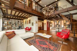 <div>
<div>
<div>
<section>
<div>
<div>
<div>
<div>
<div>
<div>
<p>In het hart van de Antwerpse binnenstad, verschuilt achter een sierlijke renaissance-gevel, schuilt een duplex-appartement dat architecturale grandeur verbindt met de warme leefbaarheid van een authentiek herenhuis.</p>
<p>De leefruimte ontvouwt zich rondom eikenhouten balken en mondt uit in een dubbele verdiepingshoogte die volume biedt. De panoramische ramen met uitzicht op de Antwerpse daken en de naburige boomkruinen laten de ruimte baden in het licht.<br />De separate keuken, met groot raam op de binnenstad, combineert functionaliteit met karakter. <br />Via een houten trap met smeedijzeren balustrade bereikt men de open mezzanine — een brede overloop met bureauruimte of leeshoek. Deze ruimte is tevens gemakkelijk om te vormen tot een extra slaapkamer. Verder beschikt het appartement over twee slaapkamers met eigen badkamer. <br />Een extra troef is de afgesloten garage die te koop is aan 35.000 euro. <br />De combinatie met de locatie in de Braderijstraat — op wandelafstand van de Grote Markt, de Scheldekaaien en gezellige HoReCa — maakt van dit appartement een thuis voor mensen met een liefde voor authenticiteit, kunst en stedelijk leven.</p>
</div>
</div>
</div>
</div>
</div>
</div>
</section>
</div>
</div>
</div>