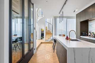 Uitzonderlijke penthouse dat luxe, comfort en verfijning naadloos combineert.<br />Gelegen in een modern gebouw uit 2020, biedt het een spectaculair uitzicht en een royale bruto woonoppervlakte van 254 m².<br /><br />Met drie afzonderlijke terrassen (97 m² bruto) geniet u op elk moment van de dag van zon, licht en rust. Ontspannen wordt dagelijkse luxe dankzij de privéjacuzzi en de inpandige sauna.<br /><br />De leefruimte straalt klasse en warmte uit, mede dankzij twee stijlvolle open haarden en een hoogwaardige open keuken met kookeiland. Het penthouse is volledig uitgerust met vloerverwarming in combinatie met een energiezuinige warmtepomp, wat zorgt voor maximaal comfort en een consistent aangenaam binnenklimaat.<br /><br />Drie ruime slaapkamers en twee elegant afgewerkte badkamers bieden ruimte en rust voor het hele gezin of gasten. Dankzij het geavanceerde domoticasysteem en automatische gordijnen ervaart u een moeiteloze controle over sfeer, verlichting en privacy.<br /><br />Met een uitstekende EPC-score van 60 en energielabel A is dit penthouse duurzaam en toekomstgericht. Praktisch gemak is verzekerd dankzij drie ondergrondse private garages, een extra staanplaats en kelderberging, rechtstreeks bereikbaar met de lift.<br /><br />Dit penthouse staat synoniem voor exclusiviteit, rust en ruimte. Een unieke kans voor wie compromisloos wil wonen in pure luxe.