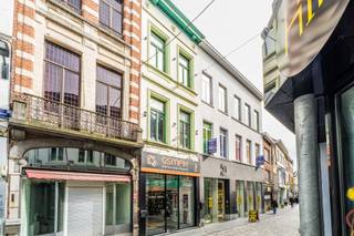In de gegeerde Basiliekstraat, in het hart van Halle, bevindt zich dit handelshuis met een bruikbare vloeroppervlakte van ca. 187 m², verdeeld over het gelijkvloers en drie verdiepingen. Dankzij de centrale ligging in de winkelstraat geniet dit pand van een uitstekende zichtbaarheid en passage.
De commerciële gelijkvloerse ruimte beschikt over een gevelbreedte van ca. 4,5 meter met ruime etalage en aparte inkom. Aansluitend bevindt zich een afzonderlijk bureel, ideaal als kantoorruimte of stockageruimte.
Verder omvat het pand een functionele keuken, een badkamer uitgerust met ligbad met douchemogelijkheid, wastafel en toilet, wat extra comfort biedt voor diverse gebruiksmogelijkheden.
Met zijn combinatie van commerciële mogelijkheden, ruime bewoonbare/verdiepingsoppervlaktes en topligging vormt dit pand een interessante opportuniteit voor investeerders of ondernemers.
Het pand is momenteel verhuurd, wat het eveneens aantrekkelijk maakt als investering met onmiddellijk rendement.