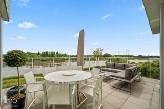 Dit stijlvolle appartement van 131 m² combineert hedendaags wooncomfort met een uitzonderlijke ligging aan de Rupel. De woning verwelkomt je in een ruime, open leefruimte waar comfort en functionaliteit centraal staan. Dankzij de grote schuiframen geniet je van een overvloed aan natuurlijk licht. Het ruime terras vormt hierbij een absolute troef met een prachtig zicht over de rivier.<br /><br />De leefruimte is strak en stijlvol ingericht en afgewerkt met hoogwaardige materialen. De moderne keuken vormt één harmonieus geheel met de woonruimte en is volledig uitgerust met ingebouwde toestellen, waaronder een inductiekookplaat, oven, koelkast en microgolfoven. Het tijdloze wit-grijze kleurenpalet zorgt voor een elegante en serene uitstraling.<br /><br />Het appartement beschikt over drie slaapkamers, momenteel ingericht als bureau, dressing en master bedroom. De master bedroom geniet eveneens van een prachtig uitzicht en beschikt over een praktische inloopdressing. De twee bijkomende kamers zijn multifunctioneel inzetbaar en bieden tal van mogelijkheden als slaapkamer, bureau of hobbyruimte.<br /><br />Verder heeft de penthouse twee badkamers. De badkamer aansluitend aan de master bedroom straalt pure luxe uit en is ingericht met een comfortabel ligbad in marmerlook, een ruime inloopdouche met zwart metalen frame en een moderne wastafel met stijlvolle kranen. Daarnaast is er een aparte, praktische douchekamer aanwezig.<br /><br />Verder is er een praktische bijkeuken met aansluitingen voor wasmachine, droogkast en een extra koelkast, wat zorgt voor extra bergruimte en optimaal gebruiksgemak.<br /><br />Tot slot zijn er twee ruime ondergrondse parkeerplaatsen inbegrepen.<br /><br />Gemeenschappelijke kosten: provisie €166,35/maand.<br /><br />Bekijk ook zeker onze website voor de grondplannen.<br />Meer info via Jean.Heylen@imovastgoed.be of via 015/34.34.54.<br />U kan Imo Vastgoed steeds vrijblijvend contacteren voor een gratis waardebepaling van uw woning.