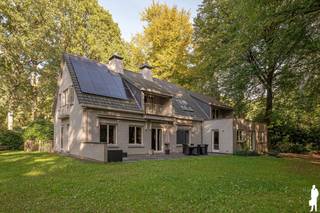 <p><strong>Bezoekmoment 24 oktober van 10u tot 13u , op afspraak.<br /><br />Ruime villa met 4 slaapkamers, 3 badkamers en dubbele garage in het groene Dennendael te Heide.</strong></p>
<p>Deze <strong>ruime villa</strong> is prachtig gelegen in een <strong>groene, bosrijke omgeving</strong> in de Hertendreef te Kalmthout. De woning biedt royale leefruimtes, <strong>vier slaapkamers waarvan drie met een eigen badkamer</strong>, een inpandige dubbele garage en een mooie tuin. Het afzonderlijk bereikbare slaapgedeelte met eigen badkamer, dressing en terras zorgt bovendien voor extra mogelijkheden.</p>
<p><strong>Gelijkvloerse verdieping</strong></p>
<ul>
<li><strong>Ruime inkomhal</strong> met gastentoilet en karaktervolle houten trap naar de verdieping</li>
<li><strong>Lichtrijke woonkamer</strong> met originele parketvloer, open haard en grote raampartijen met zicht op de tuin</li>
<li><strong>Bureauruimte</strong> aan de voorzijde van de leefruimte</li>
<li><strong>Ruime eetkamer </strong></li>
<li><strong>Leefkeuken</strong>, voorzien van een kookeiland met gasvuur, dampkap, koelkast, combi-oven en vaatwasser met echtstreekse toegang vanuit de keuken en eetkamer tot de tuin</li>
<li><strong>Twee schuifdeuren</strong> waarmee de leefruimtes van elkaar afgesloten kunnen worden</li>
<li><strong>Zeer ruime wasplaats</strong></li>
<li><strong>Inpandige dubbele garage</strong> met verwarming, ramen en zijdeur</li>
</ul>
<p><strong>Eerste verdieping</strong></p>
<ul>
<li>Ruime <strong>vide</strong> bereikbaar via de houten trap</li>
<li><strong>Slaapkamer 1</strong> met inloopkast en aansluitende badkamer met ligbad, toilet en lavabo</li>
<li><strong>Slaapkamer 2</strong> met ingemaakte kast en eigen badkamer met douche, toilet en lavabo</li>
<li><strong>Slaapkamer 3</strong>, geschikt als kinder-, logeer- of hobbykamer</li>
</ul>
<p><strong>Afzonderlijk bereikbaar slaapgedeelte</strong></p>
<ul>
<li><strong>Vierde slaapkamer</strong> in het aangebouwde gedeelte, bereikbaar via een aparte trap aan de andere zijde van de woning</li>
<li><strong>Ruime master bedroom</strong> met inloopkast en aansluitende badkamer met ligbad, douche, dubbele lavabo en afzonderlijk toilet</li>
<li><strong>Groot dakterras</strong></li>
<li>De afzonderlijke bereikbaarheid biedt extra privacy en mogelijkheden voor een inwonend familielid of een ouder kind</li>
</ul>
<p><strong>Kelder en zolder</strong></p>
<ul>
<li><strong>Gedeeltelijk onderkelderd</strong>, met droge kelder en aparte technische ruimte</li>
<li>Extra bergruimte op de zolderverdieping</li>
</ul>
<p><strong>Tuin en buitenruimte</strong></p>
<ul>
<li><strong>Prachtige, groene tuin</strong> omgeven door volwassen bomen en weelderige beplanting</li>
<li>Ruim terras in natuursteen</li>
<li><strong>Veel privacy en een aangename, bosrijke sfeer</strong></li>
<li>Ruime oprit met parkeermogelijkheden</li>
<li>Extra garage achteraan</li>
<li>Buitenkranen en elektriciteitsvoorzieningen</li>
<li>Oriëntatie ZW</li>
</ul>
<p><strong>Bijzonderheden</strong></p>
<ul>
<li><strong>4 slaapkamers en 3 badkamers</strong></li>
<li><strong>Afzonderlijk bereikbaar slaapgedeelte</strong> met eigen terras</li>
<li><strong>Inpandige garage voor 2 wagens</strong></li>
<li><strong>11 zonnepanelen</strong></li>
<li>CV op mazout</li>
<li>Gas aanwezig</li>
<li>Rolluiken op het volledige gelijkvloers</li>
<li>Vernieuwd dak</li>
</ul>
<p><strong>Ligging</strong></p>
<p>Gelegen in de <strong>Dennendael</strong>, in een rustige, groene woonomgeving met een uitgesproken bosrijk karakter. De volwassen bomen en natuurlijke begroeiing rondom de woning zorgen voor een bijzonder aangenaam woongevoel.</p>
<p><strong>Een uitzonderlijk ruime gezinswoning voor wie op zoek is naar ruimte, privacy en veelzijdige woonmogelijkheden in een groene omgeving.</strong></p>
<p>Bewoonbare opp. 364 m² ref.: bruto vloeropp. EPC-certificaat</p>