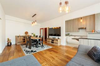 <p><span>Vous recherchez un appartement spacieux et baigné de lumière, juste à la périphérie de la ville ? Vous êtes alors à la bonne adresse. Cet appartement allie confort et solidité et dispose de nombreux équipements supplémentaires agré’. Citons notamment la climatisation’s et les volets roulants automatiques, tous deux facilement contrôlables à distance. Un logement lumineux à l’ambiance agréable où vous vous sentirez immédiatement chez vous.</span></p><p><span> </span></p><p><span>Situé dans un immeuble résidentiel bien entretenu, cet appartement se trouve au rez-de-chaussée. La porte d’entrée sécurisée donne accès à un hall d’entrée spacieux doté d’un vestiaire pratique, idéal pour ranger manteaux et chaussures. Le parquet chaleureux se prolonge harmonieusement dans le salon et le couloir de nuit, créant d’emblée une ambiance agréable et chaleureuse. L’espace de vie constitue sans aucun doute l’un des atouts majeurs de l’appartement. Grâce à l’ouverture sur la cuisine et aux grandes baies vitrées, cet espace est baigné de lumière naturelle. Le parquet apporte un charme et une chaleur supplémentaires, tandis que la surface d’ s permet d’accueillir sans difficulté un salon confortable et un coin repas, parfaits pour partager un repas convivial ou recevoir des invités.</span></p><p><span> </span></p><p><span>Cuisine ouverte sur le salon</span></p><p><span>Depuis le salon, équipé d’une climatisation réversible, la cuisine se trouve derrière un muret, ce qui permet de dissimuler soigneusement l’espace cuisine et l’évier à la vue de la pièce à vivre. Vous disposez ici de tout le confort nécessaire : une plaque de cuisson vitrocéramique, une hotte aspirante, un double évier, un lave-vaisselle, un réfrigérateur, un congélateur et de très nombreux rangements. Le comptoir de cuisine, très pratique, offre en outre un espace de travail supplémentaire et constitue en même temps l'endroit idéal pour un apéritif convivial. </span></p><p><span> </span></p><p><span>3 chambres à part entière et une buanderie séparée</span></p><p><span>Derrière le salon, vous accédez au couloir menant aux chambres, qui peut être entièrement isolé de l’espace de vie. Cela offre davantage de calme et d’intimité dans la partie nuit. De plus, l’appartement dispose de toilettes séparées pour les invités, ce qui est particulièrement pratique lorsque vous recevez des invités sans avoir à entrer dans la partie nuit. Toutes les pièces sont revêtues d’un sol stratifié facile d’entretien et équipées de volets roulants automatiques, idéaux pour profiter d’un sommeil réparateur en toute tranquillité et dans l’obscurité totale. Deux des chambres ont une superficie équivalente et offrent de nombreuses possibilités. La chambre principale est le joyau de l’espace nuit et, avec sa superficie généreuse de pas moins de 20</span><span>m²</span><span>,</span><span>elle est</span><span> particulièrement spacieuse. Grâce à ses baies vitrées, cette pièce bénéficie d’une lumière naturelle abondante. De plus, la chambre principale est équipée d’un climatiseur pouvant aussi bien refroidir que chauffer, ce qui offre un confort supplémentaire tout au long de l’année.</span></p><p><span>De l'autre côté du couloir menant aux chambres se trouvent la salle de bains et une buanderie séparée, un atout pratique au quotidien. La salle de bains est entièrement carrelée et équipée d’un deuxième WC, d’un radiateur sèche-serviettes et d’un meuble de salle de bains comprenant un lavabo, des meubles de rangement et des armoires à miroirs. Elle dispose également d’une ventilation mécanique pour un climat intérieur optimal. La buanderie séparée dispose de branchements pour une machine à laver et un sèche-linge, ce qui permet d’organiser les tâches ménagères à l’abri des regards.</span></p><p><span> </span></p><p><span>Une vie au vert avec tout à</span><span>proximité<br />Vous vivez ici dans un cadre agréable à Deurne, entouré de beaucoup de verdure. L’Ertbruggebos et le Rivierenhof se trouvent tous deux à proximité. Le Sportoase, situé sur la Ruggeveldlaan, se trouve à proximité et constitue un atout indéniable pour ceux qui aiment se détendre ou faire du sport. Écoles, supermarchés, boulangeries, pharmacies et le centre commercial Wijnegem sont tous situés à proximité. Côté mobilité, vous êtes très bien desservi : les tramways et les bus de l'August Van De Wielelei vous emmènent rapidement en ville, et grâce aux voies d'accès voisines dans toutes les directions, vous pouvez vous déplacer en un clin d'œil.</span></p><p><span> </span></p>