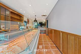 Voor meer info en foto’s, surf naar www.swevers.be – Op een centrale locatie aan de Stapelstraat 38 in Sint-Truiden bevindt zich dit instapklare handelshuis, ideaal voor ondernemers die op zoek zijn naar een commerciële uitvalsbasis met veel opslag- en werkruimte. Het pand beschikt over een bruikbare oppervlakte van 272 m² op een perceel van 1a 06ca en combineert de charme van een historisch gebouw met hedendaags comfort dankzij verschillende renovaties. Op het gelijkvloers bevindt zich de winkelruimte met achteraan een ruime keuken van 41,47 m², twee afzonderlijke koelcellen en een apart toilet. De eerste verdieping biedt een bureau, technische ruimte, berging en ongeveer 78 m² opslagruimte. Op de tweede verdieping is er nog een extra opslagplaats van circa 33 m², terwijl de ingerichte zolder van 26 m² bijkomende mogelijkheden biedt voor stockage of ondersteunende activiteiten. Het pand werd doorheen de jaren grondig vernieuwd. In 2000 werden onder meer de elektriciteit, gasinstallatie en winkelinrichting vernieuwd. In 2018 volgden een nieuw dak en de afwerking van de tweede verdieping en zolder. In 2023 werden 9 zonnepanelen geplaatst en het volledige gebouw uitgerust met energiezuinige ledverlichting. Er is een mogelijkheid tot overname van het handelsfonds voor 45.000 euro. De ligging is een grote troef: op slechts 500 meter van de Grote Markt, met winkels en restaurants op wandelafstand en een vlotte bereikbaarheid via openbaar vervoer en de snelwegen. Een uitstekende opportuniteit voor wie een instapklare commerciële eigendom zoekt op een toplocatie in Sint-Truiden. Voor meer informatie, bel 012 699 900. Bron bewoonbare oppervlakte: EPC – verslag.