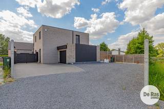 EERSTE BEZOEKDAG ZONDAG 23/8 VAN 10u TOT 14u (enkel op afspraak!)<br /><br />OPHASSELT – Bent u op zoek naar een moderne, kwalitatief afgewerkte en energiezuinige nieuwbouwwoning met veel ruimte en hedendaags wooncomfort? Dan is deze prachtige woning beslist een bezoek waard.<br /><br />Deze stijlvolle woning werd gebouwd met kwalitatieve materialen en voldoet aan de huidige normen op het vlak van isolatie en ventilatie. Hierdoor geniet u van een uiterst energiezuinige woning, voorzien van alle moderne technieken zoals vloerverwarming, een warmtepomp, ventilatiesysteem, hoogrendementsglas, zonnepanelen en airconditioning.<br />Bij het binnenkomen wordt u verwelkomd in een ruime inkomhal met gastentoilet. Vervolgens komt u in de aangename, lichtrijke leefruimte met grote raampartijen die zorgen voor een overvloed aan natuurlijk licht en een mooi zicht op de tuin. De leefruimte sluit mooi aan op de open leefkeuken, waardoor een gezellige en praktische leefomgeving ontstaat. Aansluitend bevindt zich een zeer ruime en handige bergruimte, evenals een eerste inpandige garage.<br /><br />Op de eerste verdieping beschikt de woning over een ruime overloop, drie volwaardige slaapkamers, een apart toilet en een verzorgde badkamer die uitgerust is met alle hedendaagse comfort.<br /><br />Ook buiten heeft deze woning heel wat te bieden. De volledig aangelegde en perfect zuidgerichte tuin vormt een heerlijke plek om tot rust te komen en beschikt over een ruim terras én een extra zonneterras met pergola. De tuin is volledig omheind en biedt hierdoor de nodige privacy. Daarnaast beschikt de woning over een ruime tweede buitengarage en een automatisch toegangshek vooraan.<br /><br />Een bijzonder grote troef is de ruime verharding en parkeermogelijkheid aan de voorzijde van de woning. Hier is plaats voor meerdere wagens en/of extra opslagruimte, wat bovendien bijzonder interessant kan zijn voor een kleine zelfstandige of ondernemer.<br />De woning bevindt zich op een gunstige locatie in Ophasselt, met openbaar vervoer, buurtwinkels, scholen en belangrijke invalswegen in de nabije omgeving.<br /><br />Kortom, deze prachtige en instapklare nieuwbouwwoning combineert ruimte, kwaliteit, energiezuinigheid en modern wooncomfort met een mooie zuidgerichte tuin, twee garages en bijzonder ruime parkeermogelijkheden. Een ideale woning voor wie op zoek is naar comfort én praktische extra's.<br /><br />Interesse? Aarzel dan niet en maak snel uw afspraak op 053/60.65.60.