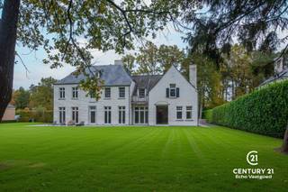 <p>In de gegeerde Bloemenwijk te Retie bevindt zich deze royale villa op een perceel van 2.415 m², waar tijdloze elegantie en hedendaagse luxe elkaar ontmoeten. De woning straalt karakter en klasse uit, met hoge plafonds, een doordachte indeling en een hoogwaardige afwerking die nog deels naar eigen smaak kan worden voltooid. Bovendien geniet u van een uitstekende bereikbaarheid, op slechts 25 minuten van zowel Eindhoven (NL) als Antwerpen (BE).<br /><br />Gelijkvloers<br />De majestueuze inkomhal met stijlvolle trappartij vormt het hart van de woning en zet meteen de toon voor het verfijnde interieur. Aan de rechterzijde ligt een ruim bureel met ingemaakte maatkasten, perfect voor wie van thuis werkt. Via dubbele deuren betreedt u het gezellige salon met gashaard, aansluitend een aparte TV-hoek en een doorgang via een elegante passerelle naar de riante family-kitchen. Deze leefkeuken biedt ruimte voor een grote eettafel, een open haard en is nog deels af te werken naar eigen voorkeur. De aansluitende bijkeuken, afgewerkt in dezelfde verfijnde stijl, biedt extra bergruimte en toegang tot de dubbele garage.<br /><br />Eerste verdieping<br />Op de bovenverdieping bevindt zich de ruime mastersuite met dressing en badkamer (nog gedeeltelijk af te werken). Daarnaast zijn er drie bijkomende slaapkamers, elk met veel lichtinval, en een praktische wasplaats.<br /><br />Tweede verdieping<br />De trap leidt verder naar de tweede verdieping, waar extra kamers zijn voorzien — ideaal als hobbyruimte, speelkamer of logeerkamer.<br /><br />Een exclusieve villa die rust, ruimte, klasse en centrale ligging perfect combineert.</p>