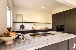 <strong>Stijlvol gerenoveerd appartement met 2 slaapkamers en zuidgericht terras in de gegeerde Elsdonkwijk</strong><br /><br /><strong>Troeven van het appartement:</strong><br />- Hoogwaardig en smaakvol gerenoveerd in 2026 <br />- Bewoonbare oppervlakte ca. 94 m² met een aangenaam zuidgericht terras van ca. 3 m² <br />- Riante lichtinval dankzij grote schuiframen met zicht op het groene straatbeeld en de karaktervolle boom vooraan <br />- Twee volwaardige slaapkamers (ca. 15 m² en 10 m²) <br />- Ruime en sfeervolle leefruimte (ca. 35 m²) met elegante sierhaard en geïntegreerde zitbank <br />- Open keuken afgewerkt met een verfijnd travertin werkblad en hoogwaardige inbouwtoestellen <br />- Praktische, aparte berging <br />- Stijlvolle badkamer met inloopdouche en travertin wastafel <br />- Gelegen op de tweede verdieping<br />- Lage gemeenschappelijke kosten (€95/maand)<br /><br /><strong>Ligging:</strong><br />- Uitstekende bereikbaarheid richting Antwerpen, Brussel en Mechelen (E19) <br />- Gelegen in de uiterst gegeerde Elsdonkwijk: een rustige, residentiële omgeving met een centrale ligging <br />- Nabij scholen, winkels, openbaar vervoer en groene wandelparken <br /><br /><strong>Indeling (ca. 94 m²):</strong><br />- Inkomhal met ingemaakte vestiairekast en gastentoilet <br />- Ruime, lichtrijke leefruimte (ca. 35 m²), afgewerkt met grote natuurstenen tegels (120x120) en een sfeervolle sierhaard die warmte en karakter brengt <br />- Open keuken (ca. 8 m²) in verfijnde Japandi-stijl, voorzien van een travertin natuurstenen werkblad en uitgerust met kwalitatieve toestellen (combi-oven/airfryer, koelkast met diepvries, vaatwasser en inductiekookplaat met geïntegreerde dampkap) <br />- Twee ruime slaapkamers (ca. 15 m² en 10 m²) op smaakvolle visgraat parket, waarvan één directe toegang biedt tot het gezellige, zuidgericht terras <br />- Badkamer met royale inloopdouche, harmonieus afgewerkt met dezelfde tegel als in de leefruimte voor een stijlvol en uniform geheel <br />- Aparte berging