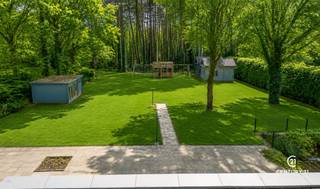 <p><strong>Unieke villa onder architectuur van Lou Jansen op royaal perceel van +3.000 m² in villawijk “De Lint”</strong></p>
<p>Op een prachtig zuidgericht perceel van meer dan 3.000 m², in de gewaardeerde villawijk <em>De Lint</em> en op wandelafstand van natuurgebied De Liereman, bevindt zich deze bijzondere woning die volledig onder architectuur van Lou Jansen (Turnhoutse School) werd ontworpen. De ligging is bovendien uitstekend: op slechts ca. 25 minuten rijden van zowel Eindhoven als Antwerpen.</p>
<p>De woning is volledig te renoveren, maar biedt dankzij haar uitzonderlijke bewoonbare oppervlakte van 334 m² en veelzijdige indeling een zee aan mogelijkheden. Verschillende binnenmuren zijn verplaatsbaar, waardoor u de ruimtes volledig naar wens kunt herinrichten.</p>
<p>De huidige indeling omvat een ruime, lichte woonkamer en een keuken die beide uitkijken op de prachtige achtertuin en het zonovergoten terras — een echte kers op de taart. Op het gelijkvloers bevindt zich bovendien een slaapkamer met ensuite badkamer en directe toegang tot de tuin. Aan de voorzijde is een bureauruimte voorzien die desgewenst als extra slaapkamer kan dienen.</p>
<p>Aan zowel de linker- als rechterzijde van de woning leidt een trap naar de bovenverdieping. Elke zijde beschikt over twee slaapkamers en een gedeelde badkamer, ideaal voor een grotere familie of logeerfunctie.</p>
<p>De inpandige garage biedt plaats aan twee wagens. In de volledig zuidgeoriënteerde tuin staan daarnaast enkele charmante chalets in goede staat, geschikt als bergruimte, atelier of hobbyruimte.</p>
<p><strong>Kortom, dit is een uniek renovatieproject waarbij u de kans krijgt om een architecturaal waardevolle woning volledig naar uw hand te zetten — een echte parel op een uitzonderlijke locatie.</strong></p>
