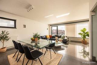 <p><span>Veel ruimte, daglicht en een strakke, hedendaagse afwerking: dit bijzondere appartement combineert een royale woonverdieping met 2 slaapkamers, dressing én heel wat ruimte. De grote open keuken, badkamer XL en het zuidgerichte terras maken het plaatje compleet. Nabij het Te Boelaarpark en Rivierenhof zit je hier ook qua locatie helemaal goed. Dubbele garage van ca. 44,5 m² is bij te huren (€300,00 per maand).</span></p><p><span> </span></p><p><span>Wonen in het licht</span></p><p><span>De woonruimte bevindt zich op de eerste verdieping. Je komt binnen in de hal op een strakke tegelvloer, die meteen de toon zet voor de rest van het appartement. Vooraan ligt de grote open leefruimte, waar keuken, eetkamer en salon mooi in elkaar overvloeien. Grote raampartijen trekken hier volop daglicht naar binnen en geven het geheel een bijzonder ruim gevoel. De witte keuken met granieten werkblad is strak, minimalistisch én uitgebreid uitgerust. Je hebt er een groot kookeiland met inductieplaat en geïntegreerde Novy-dampkap, vaatwasser, stoomoven, microgolfoven en gewone oven. De hoge kastenwand zorgt voor massa's bergruimte en er is zelfs een aparte grote diepvries voorzien. Een keuken voor wie graag kookt – en evengoed voor gasten die gezellig aanschuiven aan het eiland. Vanuit de leefruimte stap je het royale terras op: maar liefst ca. 24m² groot, over vrijwel de volledige breedte van het appartement en zuidgericht. Een fijne extra buitenruimte om van de zon te genieten.</span></p><p><span> </span></p><p><span>2 slaapkamers, royale dressing & badkamer XL</span></p><p><span>Een glazen pivotdeur scheidt het woon- van het slaapgedeelte. Hier vindt je twee volwaardige slaapkamers en een royale dressing volledig ingericht met maatkasten. Ook de badkamer mag gerust XL genoemd worden: zo’n ca.13m², volledig betegeld en dankzij de grote dakkoepel verrassend licht. Je hebt er een hoekbad, ruime walk-in douche, dubbele lavabo met groot meubel en spiegelkast, handdoekradiator en bidet. Verder zijn er op deze verdieping een apart gastentoilet en een technische ruimte met aansluiting voor wasmachine en droogkast en de Cv-installatie. </span></p><p><span>Op het gelijkvloers vind je nog een bureauruimte met wandmeubel kast, handig voor thuiswerk, met daarnaast een apart, volledig betegeld toilet met handenwasser. Op de tussenverdieping vind je extra bergruimten met een oppervlakte van circa 32m².</span></p><p><span> </span></p><p><span>Groen wonen met alles vlakbij</span></p><p><span>Je woont hier in de buurt van het Rivierenhof en Te Boelaarpark, op de grens van Borgerhout en Deurne. Het park combineert ruime grasvelden en bos met wandelpaden, een speeltuin, speelfontein en ruimte om te sporten. Ook het Boekenbergpark ligt in de buurt, met onder meer zijn bekende ecologische zwemvijver en verschillende sportmogelijkheden. </span></p><p><span>Dat vele groen combineer je hier met de voordelen van de stad: winkels, scholen en openbaar vervoer zijn in de omgeving aanwezig en de Ring en Singel zorgen voor een vlotte verbinding. Zo krijg je een bijzonder praktische uitvalsbasis voor wie graag ruim woont, zonder het groen te moeten missen.</span></p><p><span> </span></p>