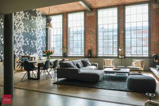 Indeling: Inkomhal met vestiaire en berg/wasruimte, lichtrijke living in parket met grote raampartijen, open volledig ingerichte keuken, trap naar de mezzanine met 2 slaapkamers  en verschillende ingemaakte kasten, badkamer (bad + douche) en afzonderlijke douchekamer aan de 2de slaapkamer. De loft geniet van aangenaam zonlicht (zuidgericht), en wordt geacclimatiseerd via de aanwezige zonnescreens, vliegenramen, airco en praktische kelderberging. Verder is er nog de mogelijkheid om een ruime autostaanplaats met laadmogelijkheden (gelegen net naast de lift) aan te kopen. Totale oppervlakte ca 180m² met een fantastisch 'loftgevoel'- wegens discretie staan niet alle ruimtes online. EPC-Score A<br /> 