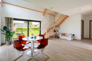 Instapklare en energiezuinige woning met tuin<br /><br />Locatie<br />Gelegen in de Kromstraat in Ranst beschik je over een vlotte verbinding naar het centrum, waar u terecht kunt voor winkels, supermarkten, scholen, horecazaken en andere dagelijkse voorzieningen. Dankzij de verbinding met de E34 en E313 bereikt u Antwerpen en omliggende gemeenten in een mum van tijd. Ook natuurliefhebbers komen hier volop aan hun trekken, met tal van wandel- en fietsroutes in de onmiddellijke omgeving. De ideale locatie voor wie op zoek is naar een perfecte combinatie van ruimte en een uitstekende bereikbaarheid.<br /><br />Beschrijving<br />Deze recente (2025) en energiezuinige prefabwoning combineert een hedendaagse architectuur met een warme, tijdloze uitstraling en een gunstig wooncomfort. Dankzij de afwerking, grote raampartijen en de prachtige vide baadt de woning in natuurlijk licht en geniet u van een aangenaam gevoel van ruimte.Via de inkomhal met ingemaakte vestiairekast betreedt u de woning. De lichtrijke leefruimte vormt zonder twijfel het hart van de woning en wordt gekenmerkt door haar open nok, zichtbare houten draagstructuur en grote schuiframen die een naadloze verbinding creëren met het terras en de tuin. De uitgeruste open keuken beschikt over een strak en tijdloos design met toestellen en voldoende werk- en opbergruimte. Op het gelijkvloers bevinden zich verder een ruime slaapkamer of bureauruimte, een stijlvolle badkamer uitgerust met ligbad en dubbele lavabo, een apart gastentoilet en een praktische berging/technische ruimte. De open trap brengt u naar de verdieping, waar de vide een bijzonder ruimtelijk gevoel creëert en uitkijkt over de leefruimte. Hier bevinden zich nog twee volwaardige slaapkamers, een tweede badkamer met inloopdouche, lavabo en toilet. Ook buiten werd aan comfort gedacht. Via de grote schuiframen bereikt u het zonnige terras dat uitkijkt over de ruime tuin, waar u in alle rust kunt genieten van het groene karakter van de omgeving. De woning beschikt bovendien over een ruime oprit. Op technisch vlak voldoet deze woning aan de hedendaagse verwachtingen. Dankzij de warmtepomp, zonnepanelen, ventilatiesysteem type D, performante isolatie en hoogrendementsbeglazing geniet u van een bijzonder energiezuinige woning met een lage energiefactuur en een uitstekend wooncomfort.<br /><br />Verplichte vermeldingen<br />P-score: D<br />G-score: D<br />Stedenbouwkundige inlichtingen: Vg, Wg, Gvkr, Gvv, Gmo