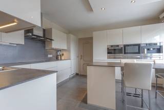 <p>Deze ruime villa uit 1980 biedt een mooie combinatie van wonen, ontspanning en tal van extra mogelijkheden. Aan de voorzijde beschikt de woning over een mooie voortuin. Links naast de woning bevindt zich het zwembad met aansluitend een ruim terras en poolhouse met douche. Achter de woning is er bovendien een groot terras.</p><p>Op het gelijkvloers beschikt de woning over een ruime inkomhal, aparte bureauruimte, toilet, ingerichte keuken met bijkeuken en aansluitende berging, een eetplaats in een ruime L-vormige leefruimte. Dankzij het grote schuifraam staat de leefruimte rechtstreeks in verbinding met het terras en de buitenruimte.</p><p></p><p>De eerste verdieping omvat een nachthal, badkamer met ligbad, douche en dubbele wastafel en vijf ruime kamers. Deze kunnen naar eigen behoefte worden ingericht als slaapkamers, bureau, hobbyruimte of fitnessruimte.</p><p><strong>Een absolute troef is de grote loods onder de woning.</strong> Deze beschikt over drie hoge inrijpoorten, een interne laadkade en frigo- en koelinstallaties. De loods biedt heel wat mogelijkheden voor een zelfstandige activiteit, opslag, werkplaats of hobby. Ook voor liefhebbers van oldtimers, verzamelaars of wie meerdere voertuigen wil stallen, is dit een bijzonder interessante ruimte.</p><p></p><p>De loods is bereikbaar via de oprit rechts van de woning via de Oude Geraardsbergsebaan, <strong>Daarnaast is er een tweede, vlottere toegang tot de loods rechtstreeks vanaf de Ninoofsesteenweg</strong>, via het afzonderlijke perceel bouwgrond. Dit perceel, inclusief deze toegang, kan apart worden aangekocht. Hierdoor beschikt de loods over een bijzonder praktische ontsluiting, ook voor grotere voertuigen of vrachtwagens. Dit maakt het geheel onder meer interessant voor een zelfstandige activiteit, opslag, een werkplaats of het stallen van voertuigen en oldtimers.</p><p></p><p>Een veelzijdig eigendom voor wie op zoek is naar een ruime woning en grote buitenruimte, gecombineerd met een uitzonderlijke loods en tal van mogelijkheden.</p><p></p><p><strong>EPC: label C – 266 kWh/m²/jaar</strong></p>