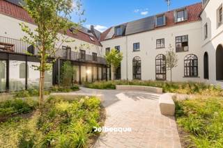 In het historische centrum van Brugge ligt Karmel, een bijzonder woonproject op de voormalige site van het Karmelklooster. Het historische karakter van het gebouw werd behouden en gecombineerd met hedendaags wooncomfort. Zo woon je op een rustige, groene plek in de binnenstad, op wandelafstand van alles wat Brugge te bieden heeft.<br /><br />Appartement A2.3 is een ruim triplexpenthouse met een bewoonbare oppervlakte van 241 m². Het appartement beschikt over 3 slaapkamers, 2 badkamers, een ruime leefruimte met vide, wat zorgt voor veel lichtinval, halfopen keuken. Het leuke effect van de ingebouwde patio (12m²) zorgt voor lichtrijk zongevoel in de leefruimte. <br /><br />De absolute troef bevindt zich op het derde niveau: een dakterras van 30m² met een uitzonderlijk 360°-zicht over de Brugse skyline. Dit ruime terras wordt dan ook nog eens begrensd met mooie groenzones. Een unieke buitenruimte die het appartement een bijzonder karakter geeft.<br /><br />Dit appartement heeft dus heel wat buitenruimte te bieden op dé stilteplek in Brugge. Ideaal voor wie rust in de stad zoekt. <br /><br />De grootste werken zijn intussen achter de rug. Als koper krijg je nog de ruimte om de laatste afwerkingskeuzes zelf te maken en het appartement zo verder vorm te geven volgens je eigen stijl.<br /><br />Ook op het vlak van duurzaamheid werd Karmel toekomstgericht uitgewerkt. Ook technisch is het appartement bijzonder compleet uitgerust, met geothermische verwarming en koeling, vloerverwarming, ventilatiesysteem D met warmterecuperatie, zonnepanelen en regenwaterrecuperatie. De hoogwaardige basisafwerking omvat onder meer eiken parket, uitgeruste badkamers en een keuken met natuurstenen werkblad en toestellen. De laatste materiaal- en interieurkeuzes kan je als koper nog mee bepalen.<br /><br />Karmel combineert zo een unieke historische locatie met rust, ruimte en modern wooncomfort, midden in het centrum van Brugge.<br /><br />Wil je dit bijzondere appartement en de site zelf ontdekken? Contacteer ons voor een bezoek ter plaatse via 050 45 03 45 of info@delbecque.immo.