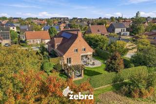 Op zoek naar een ruime, instapklare woning waar rust, comfort en ruimte centraal staan? Dan is deze charmante open bebouwing absoluut een bezoek waard!<br />De woning is gelegen op een perceel van 800 m² en geniet van een topligging in een doodlopende straat, met een groene zone achter het perceel. Hier geniet je van een rustige en aangename woonomgeving, omgeven door groen en met de nodige privacy.<br /><br />Bij het betreden van de woning kom je terecht in de inkomhal met gastentoilet. Verder beschikt het gelijkvloers over een praktische bureauruimte, ideaal voor thuiswerk, en een lichtrijke, ruime woonkamer met gezellige zithoek en eetplaats. Dankzij de grote raampartijen geniet je hier van een mooie lichtinval en een aangenaam zicht op de tuin. Aansluitend bevindt zich de volledig ingerichte keuken, voorzien van alle nodige toestellen.<br /><br />Daarnaast bevinden zich op het gelijkvloers twee slaapkamers en een badkamer, uitgerust met een dubbele lavabo, ligbad en aparte douche. Ook de praktische wasruimte en de dubbele garage met automatische poorten bevinden zich op deze verdieping, wat zorgt voor extra comfort en gebruiksgemak.<br /><br />Op de eerste verdieping bevinden zich nog twee slaapkamers en een ruime zolder van maar liefst 66 m², die tal van mogelijkheden biedt. Bovendien beschikt de woning over een kelder, ideaal als extra opbergruimte.<br /><br />Buiten is het heerlijk vertoeven in de verzorgde, fraai aangelegde tuin met gezellige terrassen. Het overdekte terras sluit mooi aan op de woning en vormt de ideale plek om in alle rust te genieten. De groene omgeving en de mooie hagen zorgen bovendien voor een aangenaam gevoel van privacy.<br /><br />Ook op vlak van energiezuinigheid en comfort heeft deze woning heel wat te bieden! Met een gunstige EPC-score van slechts 204 kWh/m² per jaar (label C) scoort de woning bijzonder goed. Bovendien behoort een EPC-label B met een beperkte energetische aanpassing tot de mogelijkheden.<br />De woning beschikt daarnaast over recente ramen uit 2017, elektrische rolluiken en zonnewering aan zowel de oostelijke als de zuidelijke zijde.<br /><br />Extra troeven zijn de aanwezige zonnepanelen, een regenwaterput van maar liefst 10.000 liter en vliegenramen doorheen de woning.<br /><br /><strong>Ook wild geworden van deze thuis?<br />Twijfel dan niet langer en leg vandaag nog uw bezoek vast!</strong>