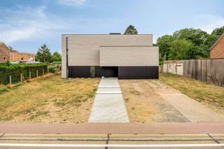 <p>–<strong>Interessante aankoopformule onder registratierechten</strong>–</p><h2><strong>Architecturale nieuwbouwvilla te Vissenaken:ongeziene luxe en ruimte, hoogwaardig afgewerkt</strong></h2><p>Dat tegenpolen elkaar aantrekken, bewijst deze architecturale nieuwbouwvilla uit 2023. Ze laat zich kenmerken door een robuust silhouet met een verfijnd karakter. Een ware statementwoning die tegelijkertijd sereniteit hoog in het vaandel draagt. Hier beleeft u gegarandeerd steeds het beste van twee, en veel meer, werelden.</p><p>Op een perceel van circa 30 are treft u deze vondst, gekenmerkt door een zandkleurige gevel met een zeldzame vorm van tijdloosheid. Aan de straatzijde houdt de architectuur zich bewust meer gesloten: een doordachte keuze die privacy creëert en het binnenleven afschermt van de straat. Het strakke design omhult maar liefst 500 m² bewoonbare oppervlakte en wordt omringd door – nu nog vrij in te richten – flora en vermaak. Van een oranjerie of moestuin tot een natuurlijke zwemvijver, maar evengoed een poolhouse met luxe buitenkeuken. Met een glas champagne in de hand droomt u vanuit de jacuzzi alvast van dat buitenplan.</p><p>Waar de woning zich vooraan bewust afsluit van de straat, opent ze zich achteraan volledig naar het landschap. Dankzij de achterste glasgevel lijken interieur en landschap door elkaar te zweven. Op het gelijkvloers geniet u zo van een open en lichtrijke leefruimte, met nog aanpalend twee flexibel inzetbare ruimtes, ideaal als bureau, atelier, speelkamer, extra leefruimte of slaapkamer.</p><p>Overlopend in de high-end, hoog afgewerkte keuken: inclusief Dekton werkblad, premium Siemens toestellen en maatwerk tot in de kleinste lade. Minimalistisch ogend, maximalistisch in gebruik. En de technologie, die verdwijnt in het maatwerk dankzij onder andere de ingewerkte dampkap en toegang tot het volledig geïntegreerde Loxone Smart Home systeem. Verlichting, screens, audio en meer worden zo met één knop bediend terwijl u hetzelfde doet voor uw gasten.</p><p>Op de eerste etage bevinden zich vier slaapkamers. De hoofdslaapkamer vormt samen met de ruime dressing en ensuite badkamer een mooi geheel: ontwaken met een weids uitzicht, vervolgens door naar de dressing en aansluitend de badkamer. Die werd verfijnd afgewerkt met onder meer een dubbele wastafel van Axor en een bad met corian afwerking. Ook de tweede badkamer op deze verdieping beschikt over een moderne inloopdouche. Comfort en afwerking trekken hier duidelijk dezelfde lijn.</p><p>Op de bovenste etage treft u letterlijk vrijheid van het hoogste niveau. Want deze polyvalente verdieping kan bestemd worden tot exclusief thuiskantoor, maar evengoed tot bibliotheek, ruimte voor een vrij beroep of zelfs kangoeroewoning. En dankzij de lift navigeert u in alle discretie tussen de etages zonder het private woondeel te doorkruisen. Een uitzonderlijke troef met ook een toekomstgericht doel.</p><p>En eveneens in de kelderverdieping liggen de mogelijkheden letterlijk aan de voeten: van een cosy cinema tot een exclusieve wijnkelder, of van een homegym tot een infraroodcabine. Van spanning tot ontspanning: wat u kiest, beleeft u binnenkort thuis. Tot slot geniet u royaal en blijft de impact op uw energiefactuur toch beperkt, want dankzij een geothermische warmtepomp, passieve koeling, zonnepanelen en driedubbele beglazing geniet u van een uitzonderlijk laag E-peil E5.</p><figure><div></div></figure><p></p>