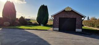 <br />Welgelegen EENGEZINSWONING, open bebouwing, type BUNGALOW (rustiek), met mooie tuin, aparte garage en aangename leefruimtes op 9 are 97 ca.<br />Indeling: Ruime inkom, living, volledige ingerichte keuken, ingerichte badkamer met aansluitingen voor de wasmachine/droogkast, apart wc; nachthal, 2 slaapkamers, vaste trap naar zolderverdieping. Hier bevindt zich nog een apart wc met douche. De huidige dubbele beglazing zal vervangen worden door volledig nieuwe ramen, ralkleur: beige, met rolluiken. de garage krijgt ook nieuwe ramen en sectionaal poort. ((Dubbele beglazing HR-glas, rolluiken)), centrale verwarming op aardgas. Het dak op de woning is nieuw en de elektriciteit is conform (vernieuwd in 2023). Berg-,voorraad en chauffagekelder.<br />Buiten: mooie aangelegde tuin, overdekt terras, en losstaande ruime garage. EPC: 342 kWh/m²jaar. De woning kan eventueel ook aangekocht worden: VP 442.000,00 euro, exclusief kosten;. Goede ligging en bereikbaarheid. Een praktische ingerichte woning! De woning is vrij .