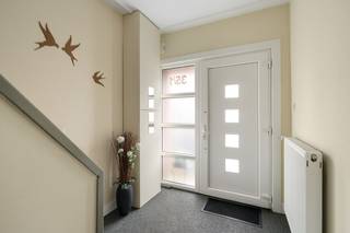 Deze bijzonder ruime woning is gelegen in de gezellige Walenhoek, midden in het polderdorp Zandvliet. Hoewel de woning zich vlakbij het centrum bevindt, is het hier toch erg rustig wonen. Winkels, scholen en openbaar vervoer zijn allen in de directe omgeving terug te vinden. Ook is er een erg goede verbinding met de A12 en de haven van Antwerpen. In 2011 onderging de woning een prachtige renovatie, waarbij comfort, natuurlijke lichtinval en een ruimtelijk gevoel centraal stonden. Binnenkomen doet u via een aparte inkomhal, vanwaar u meteen toegang heeft tot een aangenaam ruime leefruimte. Verschillende raampartijen zorgen ervoor dat er een super aangenaam daglicht binnenvalt in deze woonkamer. Grenzend aan de leefruimte bevindt zich de comfortabel ingerichte keuken. Verder vindt u op het gelijkvloers nog een apart gastentoilet, een achterinkom met ingemaakte kast en een grote berging, eveneens voorzien van een ingemaakte kastenwand. Op de 1e verdieping bevinden zich 2 erg ruime slaapkamers met veel lichtinval, een bureau, een dressing en een grote badkamer met dubbele wastafel met meubel, toilet, ligbad en douche. De 2e verdieping is ingericht als een ruime, karakteristieke slaapkamer met open mezzanine, dewelke nog flink wat opbergruimte biedt. Verder vindt u op deze verdieping nog een praktische bergzolder, dewelke opnieuw heel wat ruimte biedt om extra spulletjes in te stockeren. De zuidwest-gerichte koer vormt een bijzonder gezellig plekje om in alle rust en privacy van de buitenlucht te profiteren. Ze werd verhard met klinkers en is bovendien voorzien van een zonnetent, ideaal om ook op zonnige dagen comfortabel buiten te zitten. Vooraan, naast de woning, geeft een poortje toegang tot een praktisch afdak waar u gemakkelijk fietsen of een voorraad hout kan stockeren.